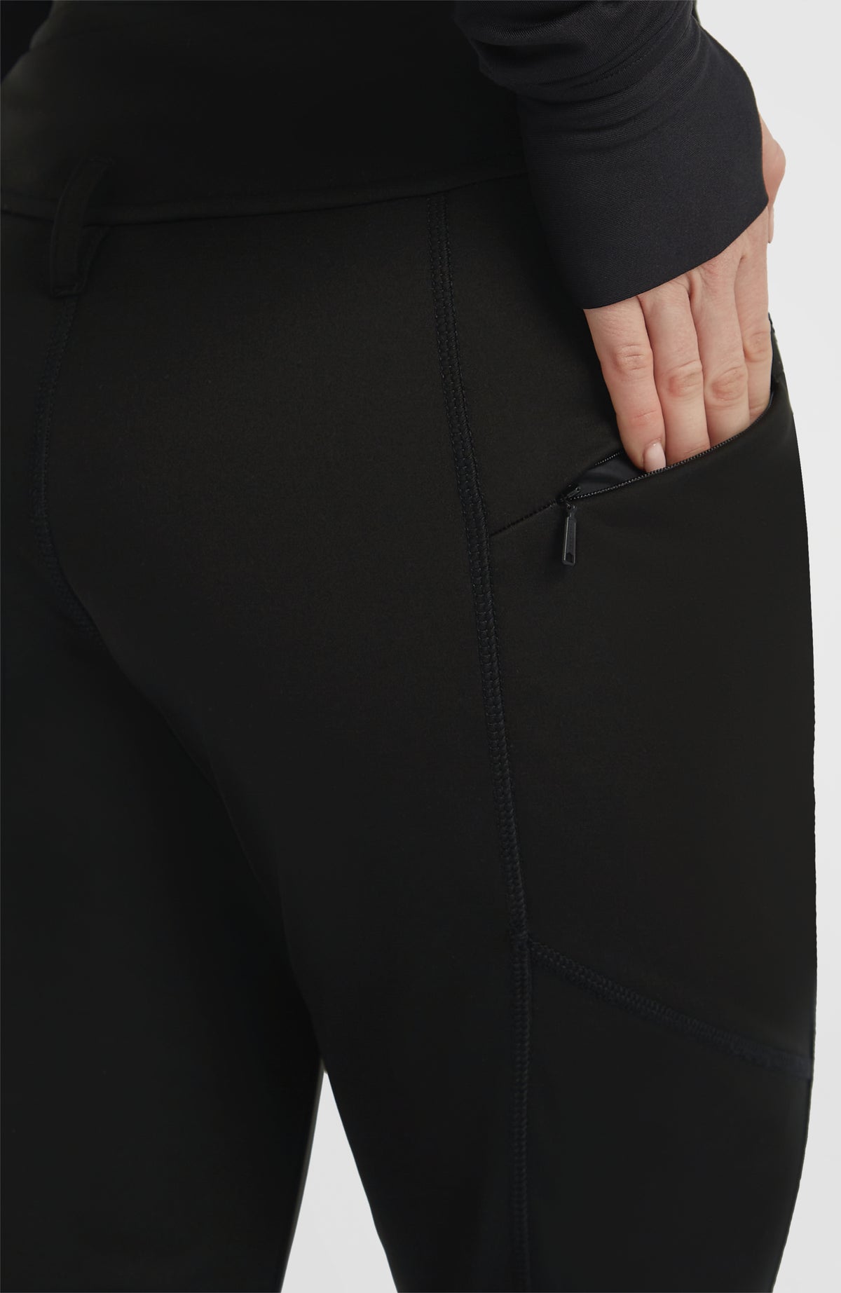 Nahaufnahme der Reißverschlusstasche an der Seitennaht der schwarzen FWC'Cruz Softshell-Skihose für Damen