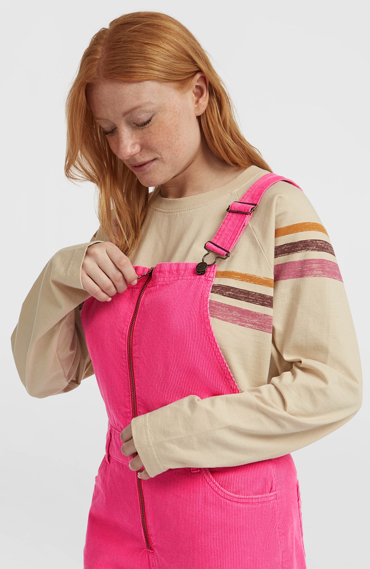Nahaufnahme von Reißverschluss und Trägern der pinken O'Riginals Cord-Latzhose am Model