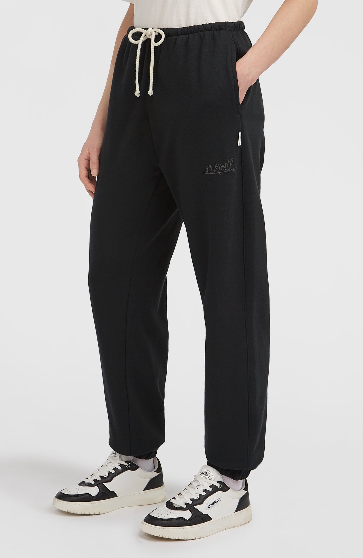 Essentials Script Jogginghose für Damen, schwarz, Seitenansicht am Model mit dezentem Logo-Schriftzug