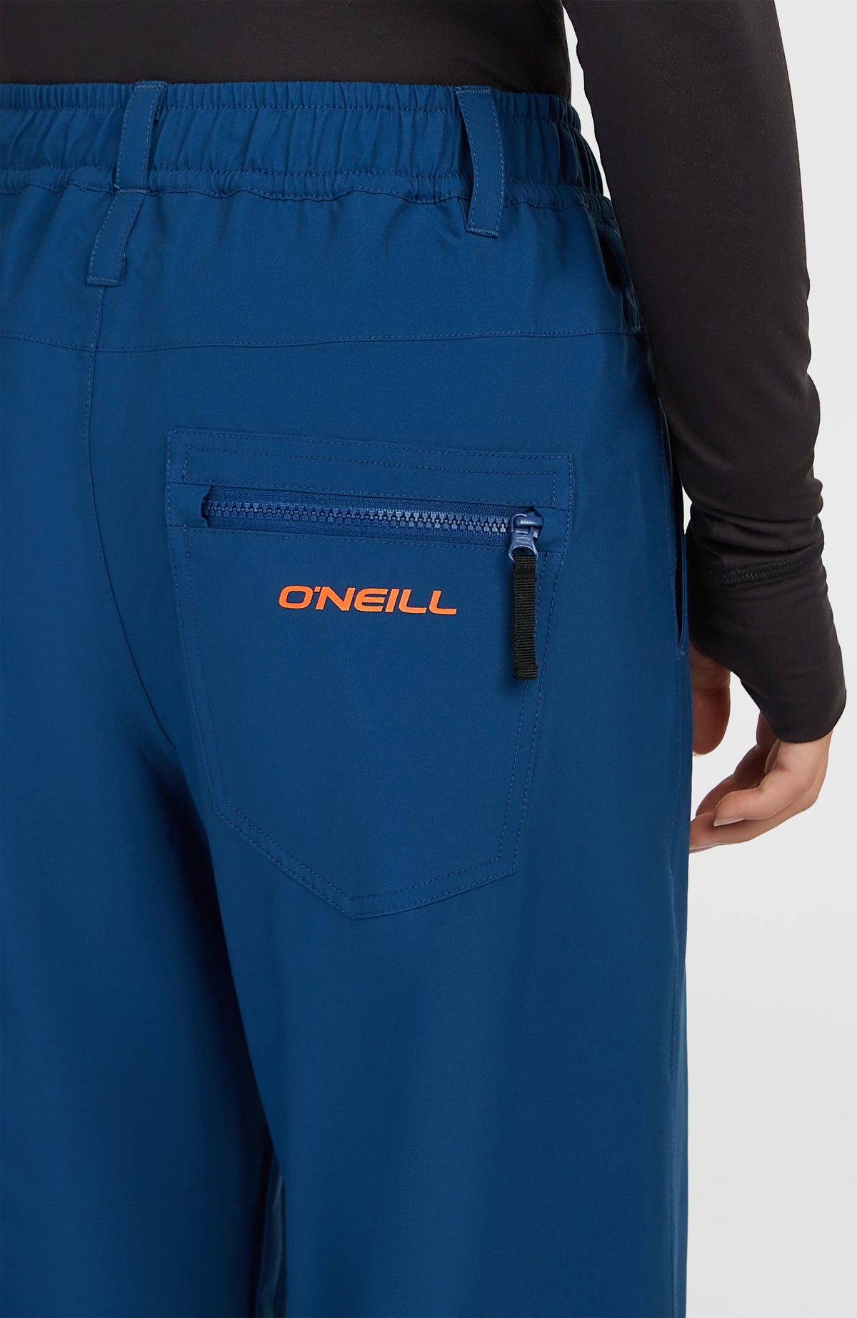 Nahaufnahme der Gesäßtasche mit Reißverschluss und Logo der blauen FWC Oversized Ski- und Snowboardhose