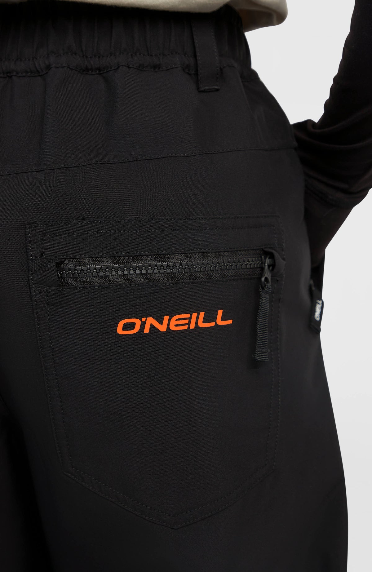 Nahaufnahme der Gesäßtasche mit Reißverschluss und Logo-Schriftzug der schwarzen FWC Oversized Ski- und Snowboardhose