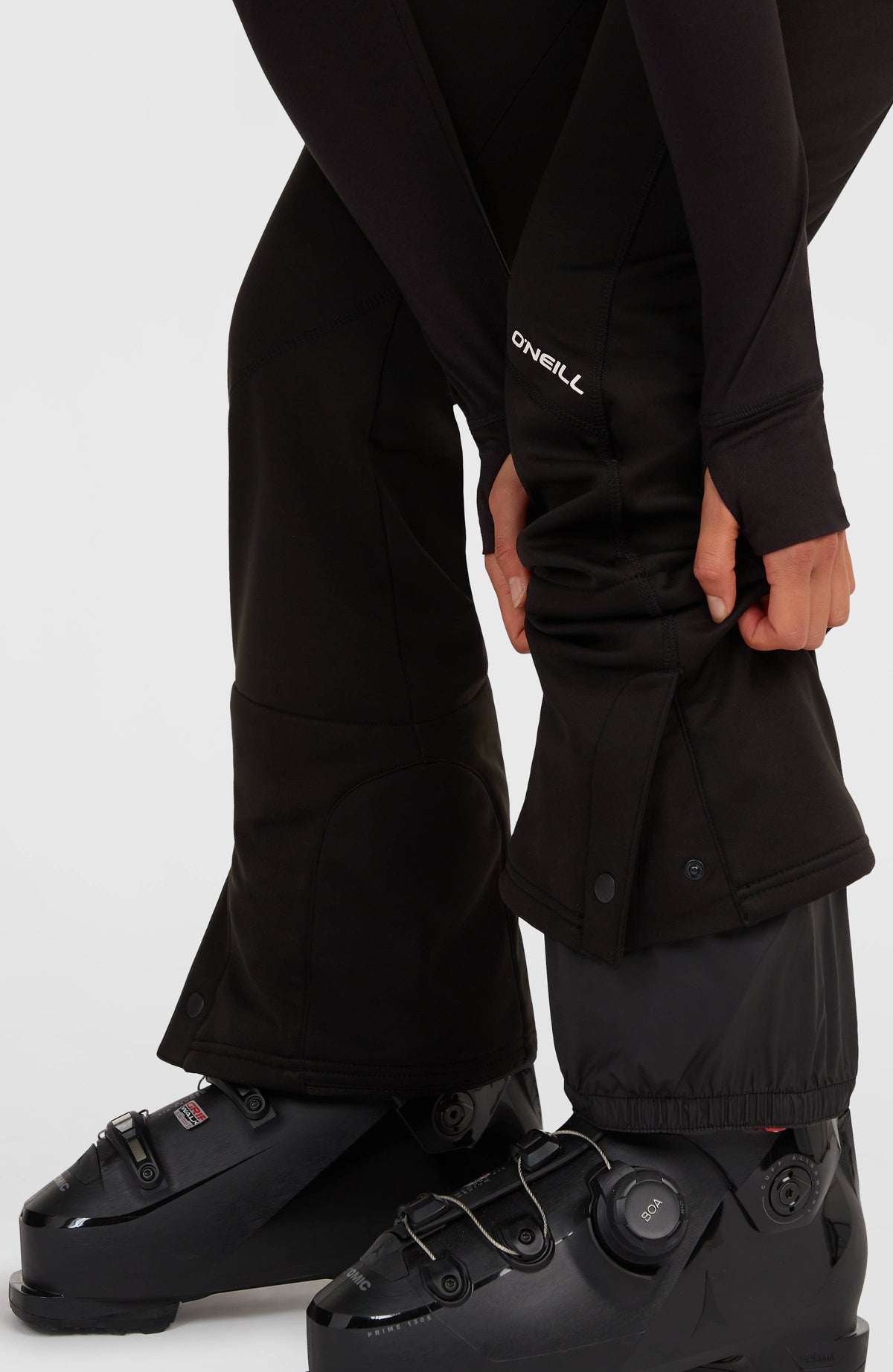 Nahaufnahme vom verstellbaren Saum der schwarzen FWC'Cruz Softshell-Skihose am Model