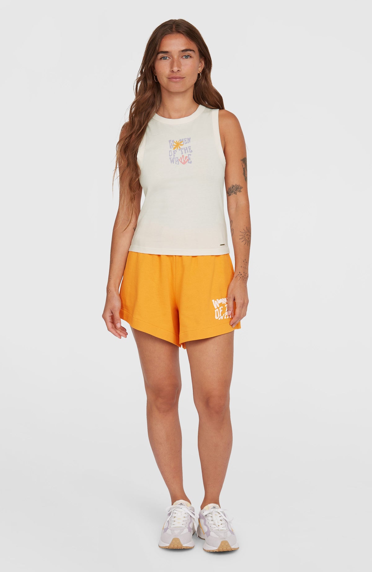 Women of the Wave Sweatshorts für Damen, orange mit Logo-Print in Weiß, Ganzkörperansicht von vorne am Model