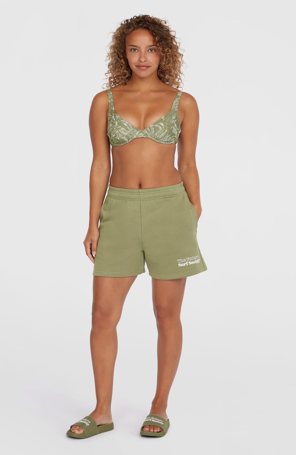 Future Surf Society Shorts für Damen, grün mit Logo-Print in Weiß, Ganzkörperansicht von vorne am Model