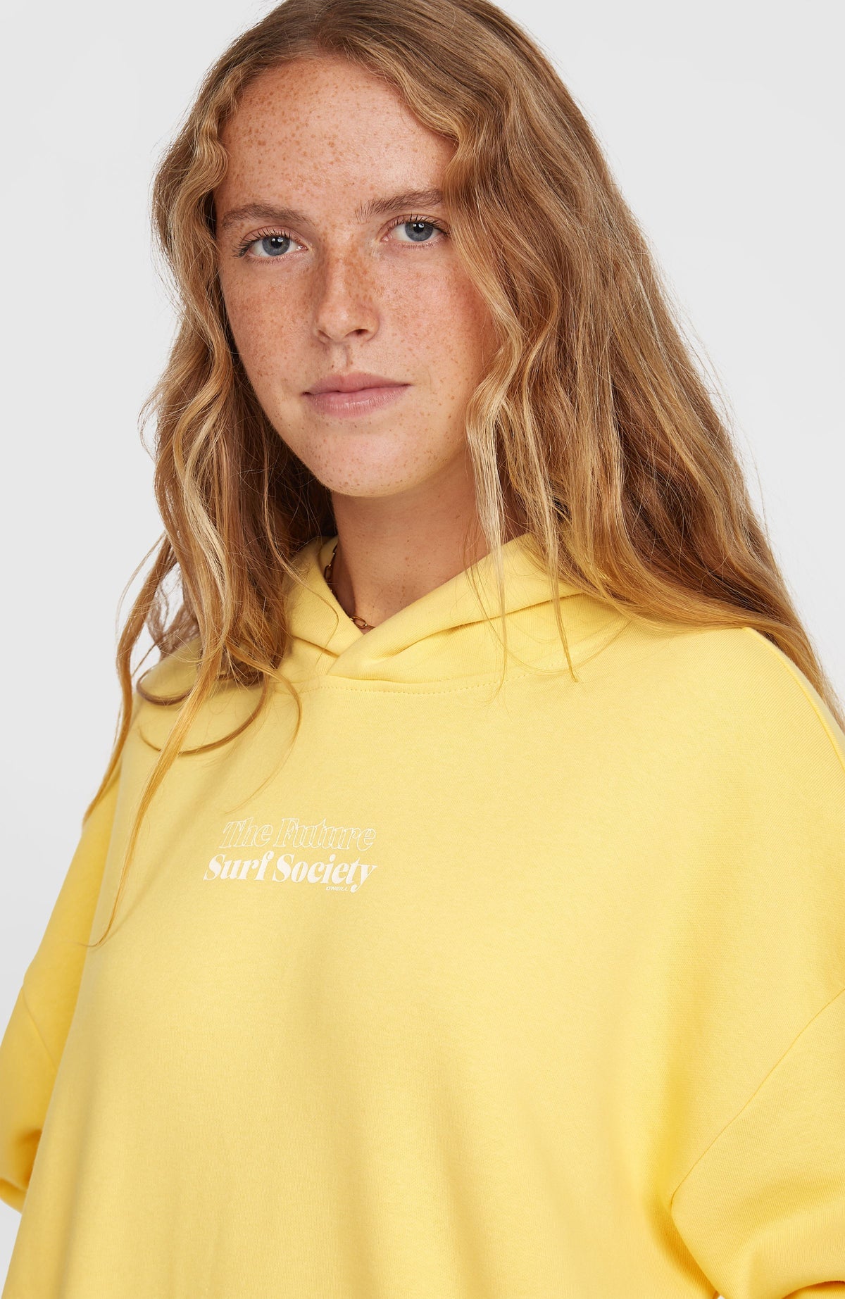 Nahaufnahme von Ausschnitt und Schriftzug-Print in Weiß des gelben Future Surf Society Hoodie am Model