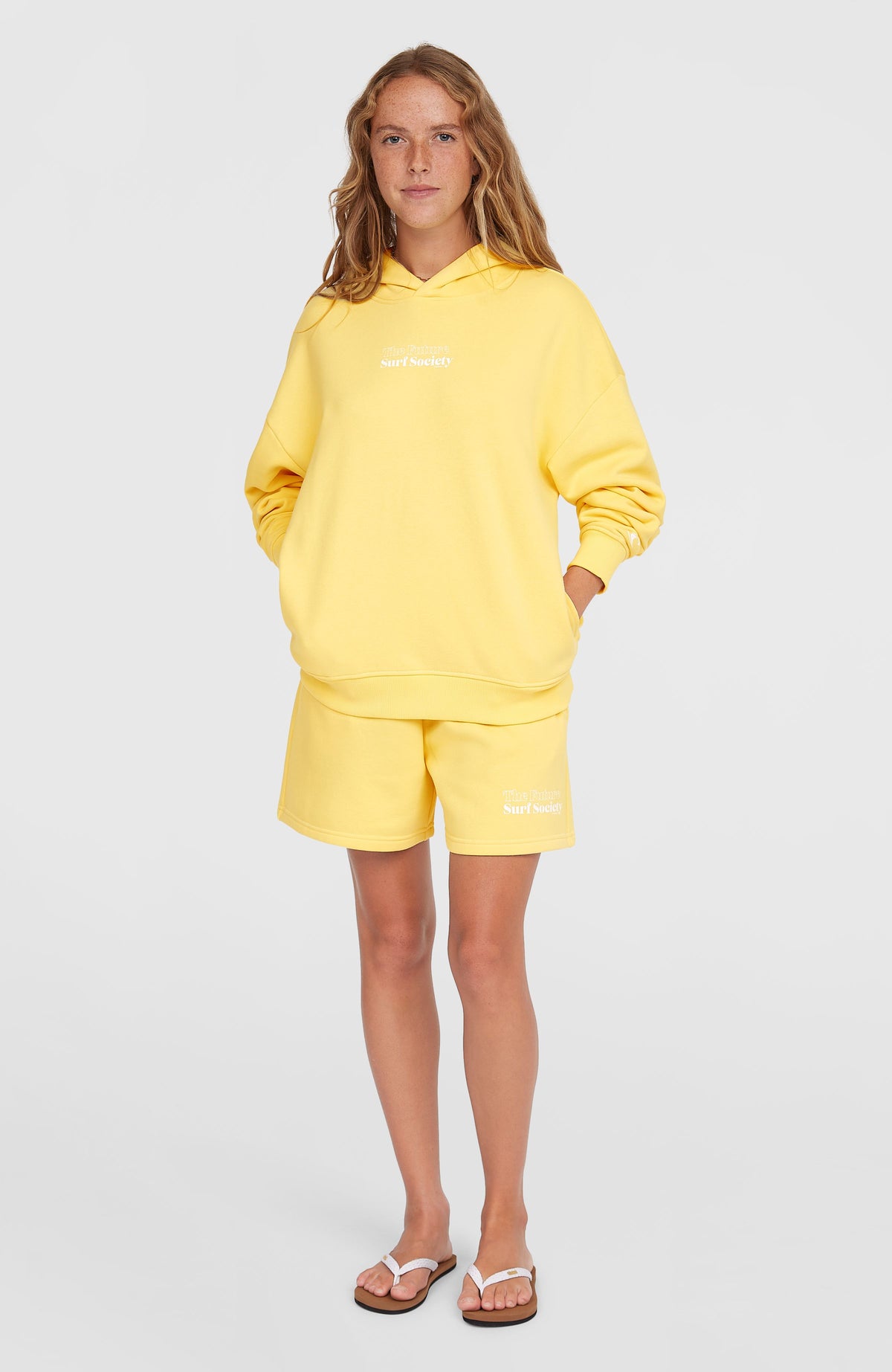 Future Surf Society Hoodie für Damen, gelb mit Schriftzug-Print in Weiß, Ganzkörperansicht am Model von vorne