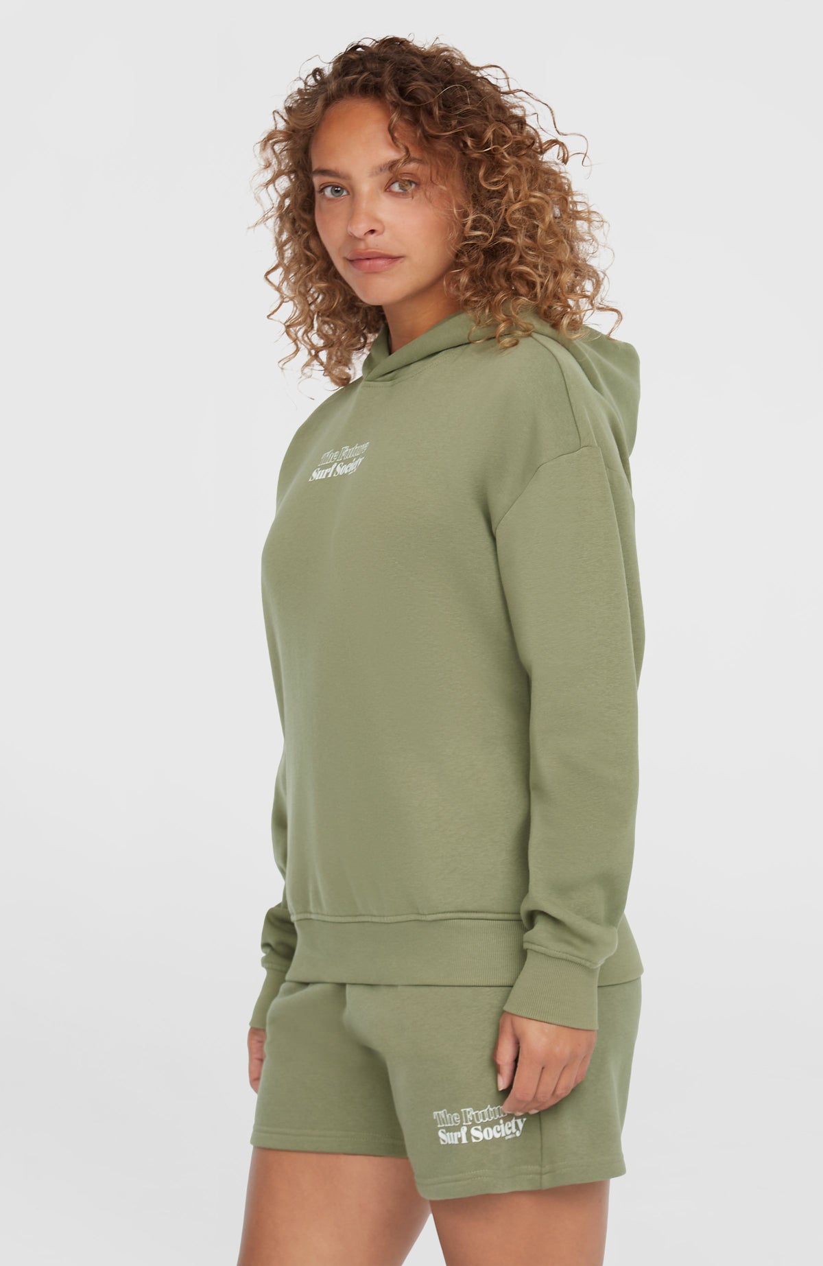 Future Surf Society Hoodie für Damen, grün mit Logo-Print in Weiß, Halbprofil und Seitenansicht am Model