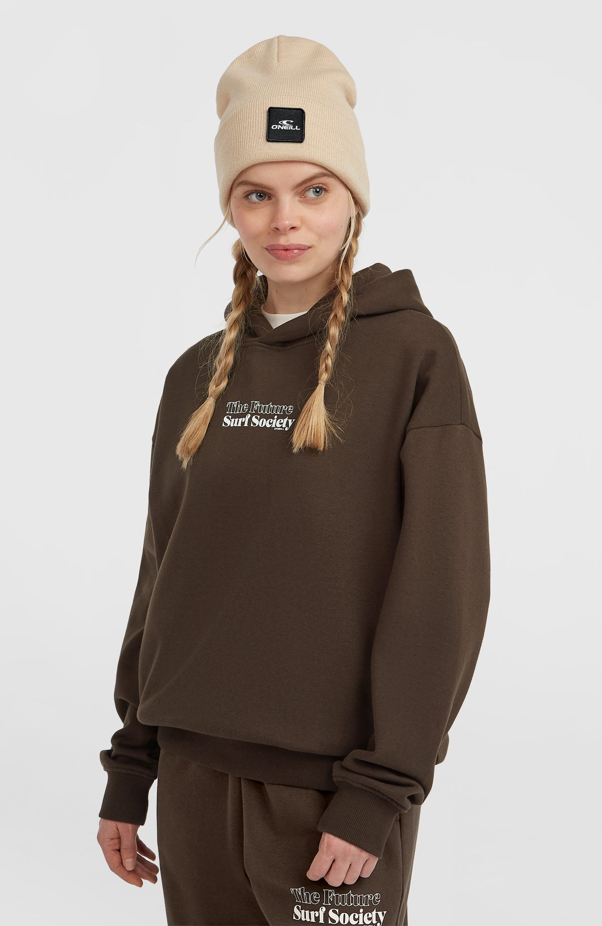 Future Surf Society Hoodie für Damen, braun mit Logo-Print in Weiß, Halbprofilansicht am Model