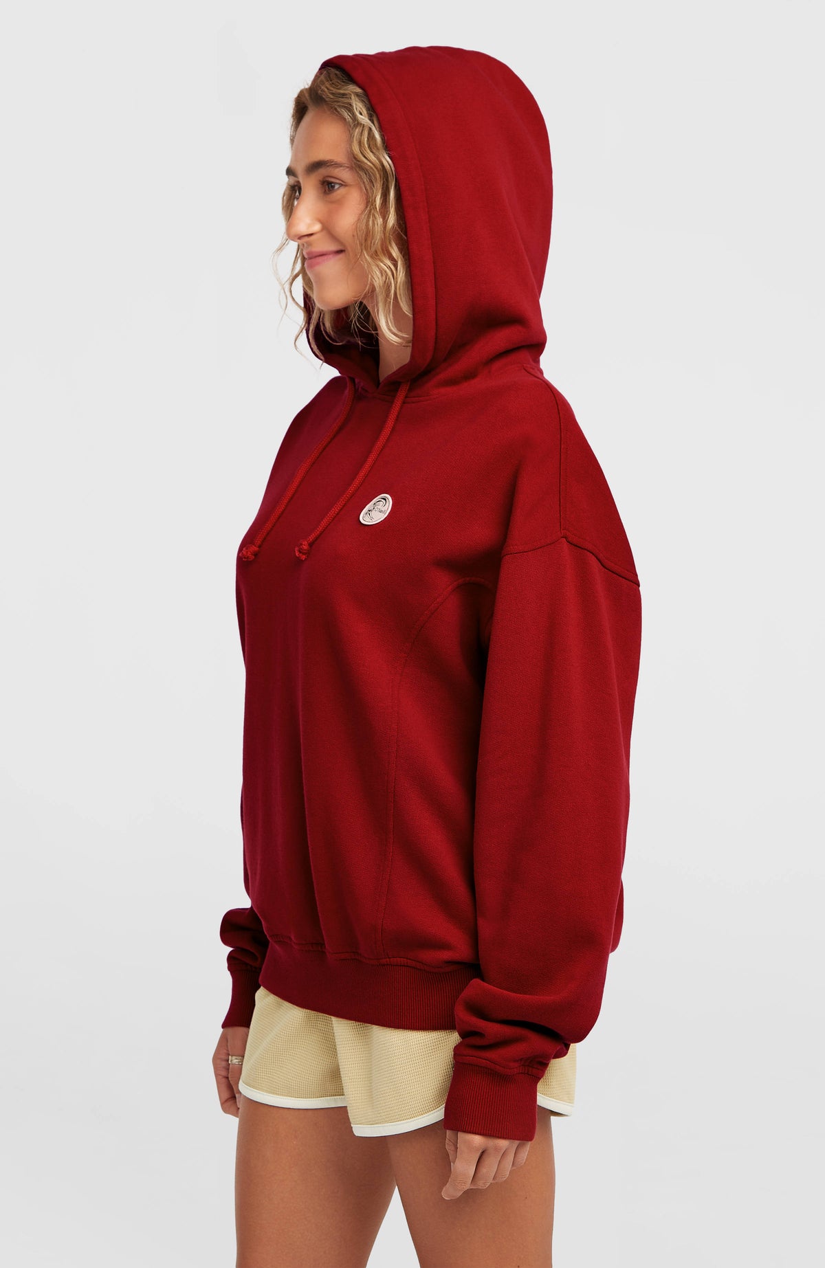 O'Riginals Hoodie für Damen, rot, Seitenansicht getragen am Model mit aufgesetzter Kapuze und Tunnelzugkordel