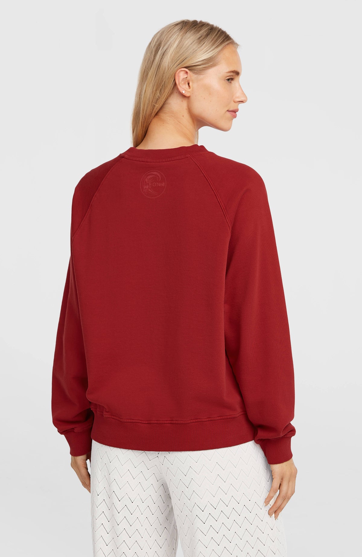 O'Riginals Crewneck Sweatshirt für Damen, rot, Rückansicht am Model mit dezentem Logo-Print unter dem Kragen