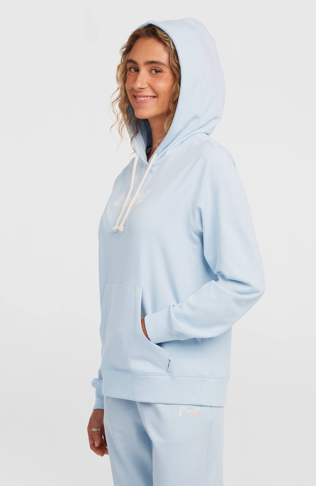 Essentials Script Hoodie für Damen, blau, Seitenansicht am Model mit aufgesetzter Kapuze und Kängurutasche