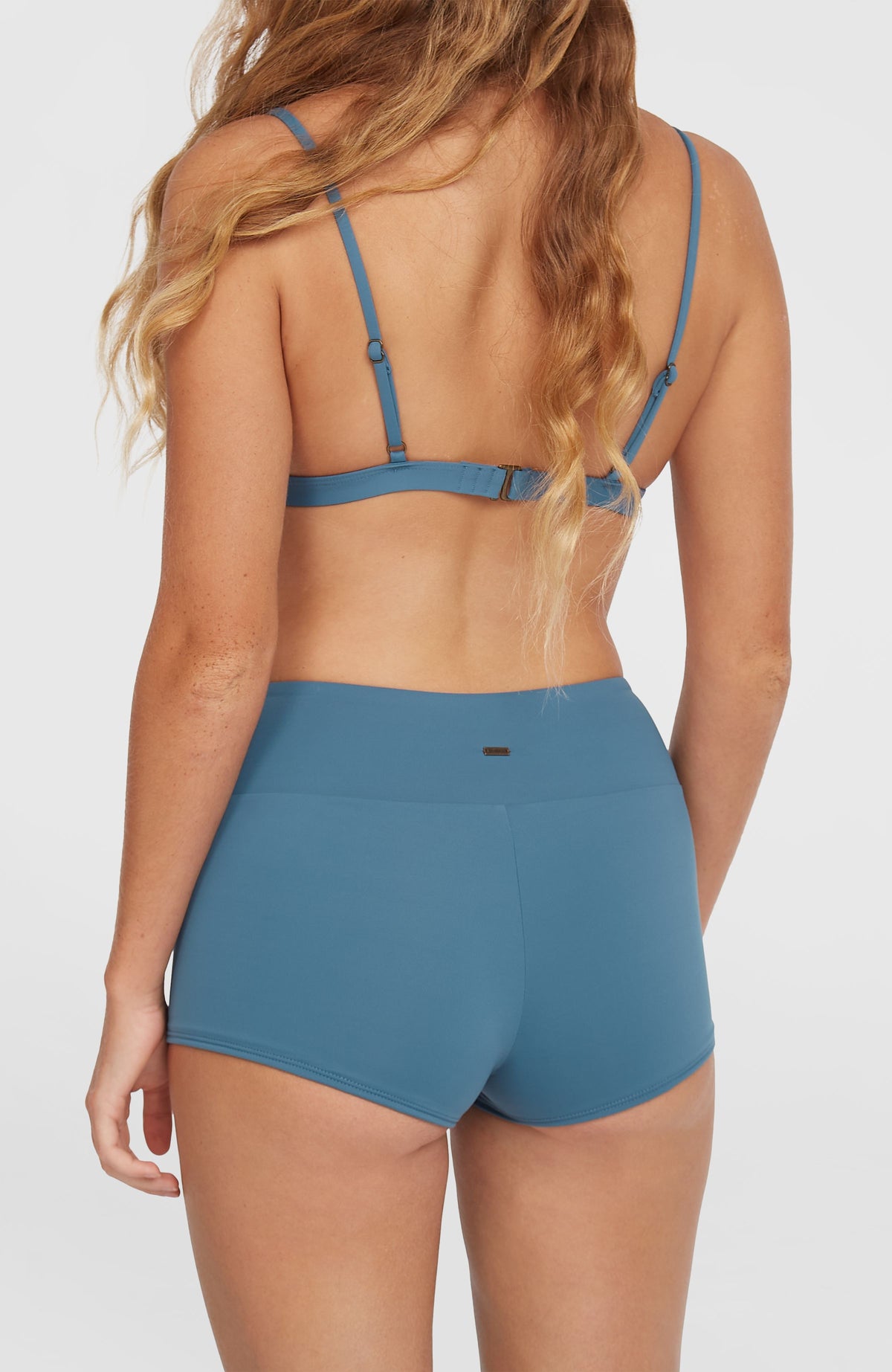 O'Neill Grenada Bikinihose für Damen, blau, Nahaufnahme der Rückseite am Model mit kleiner Logo-Plakette