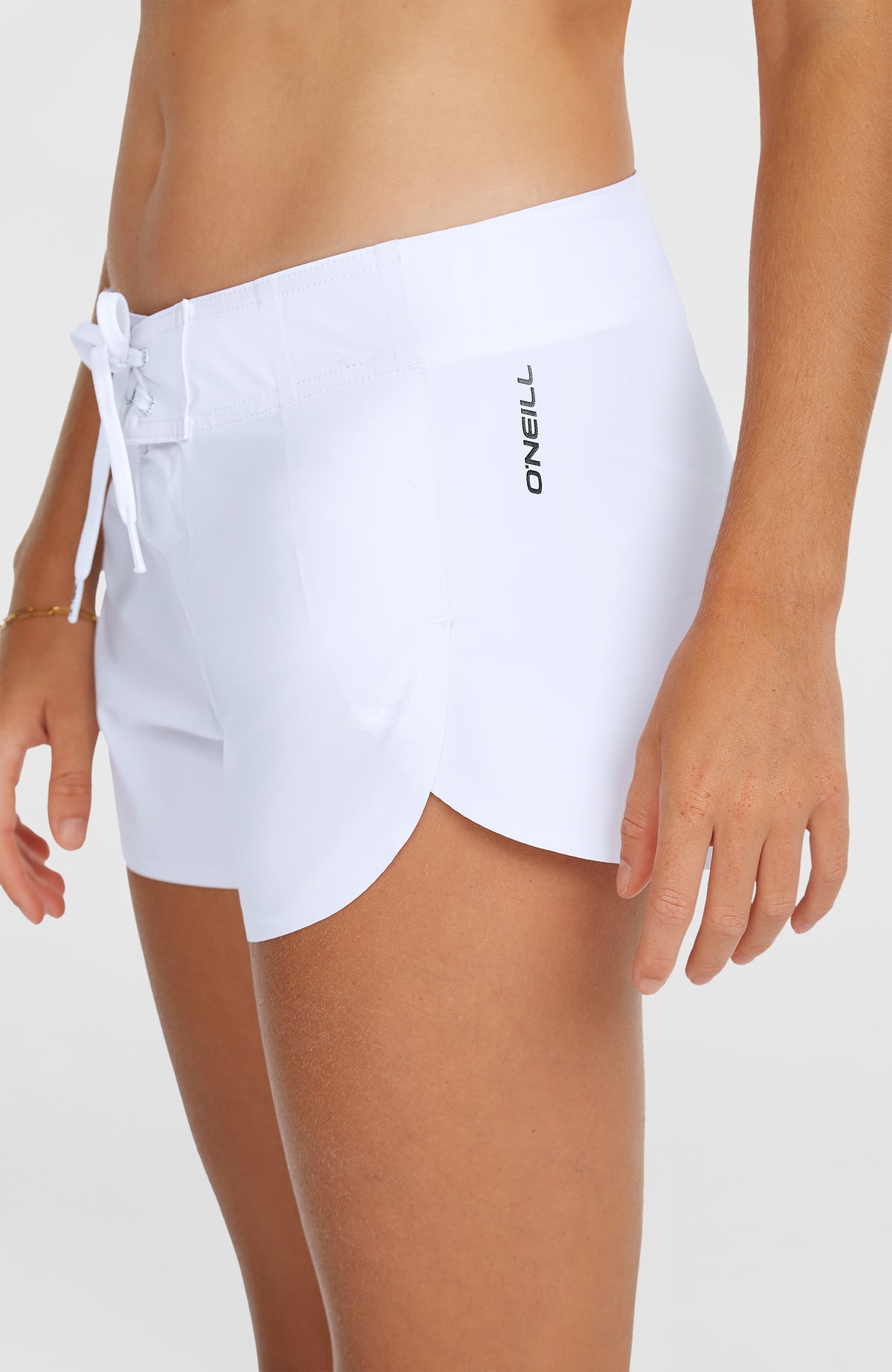 Nahaufnahme der weißen Hyperfreak Tech Boardshorts am Model mit seitlichem Logo-Schriftzug am Saum
