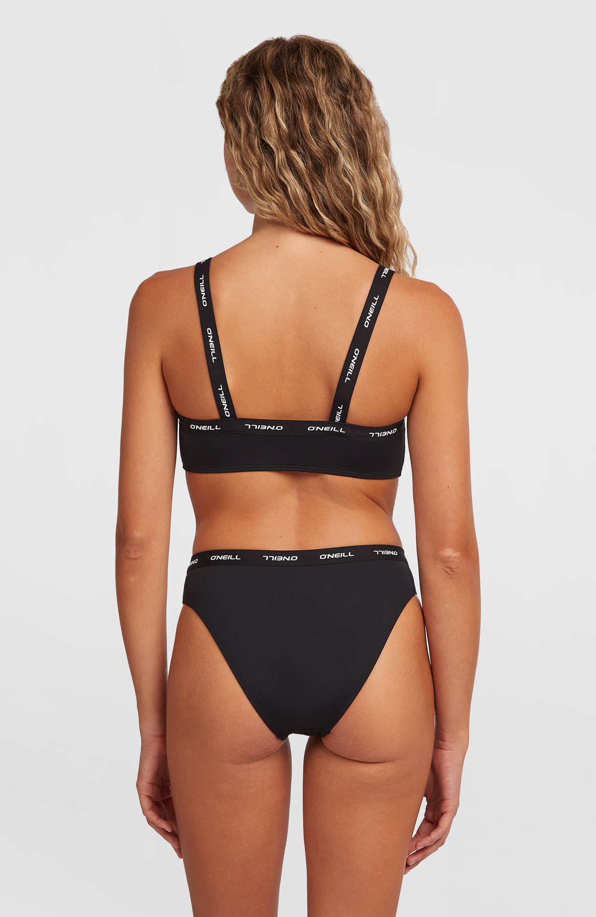 Sport Bikini-Set für Damen, schwarz, Rückansicht mit elastischem Logo-Bund an der Bikinihose, am Model