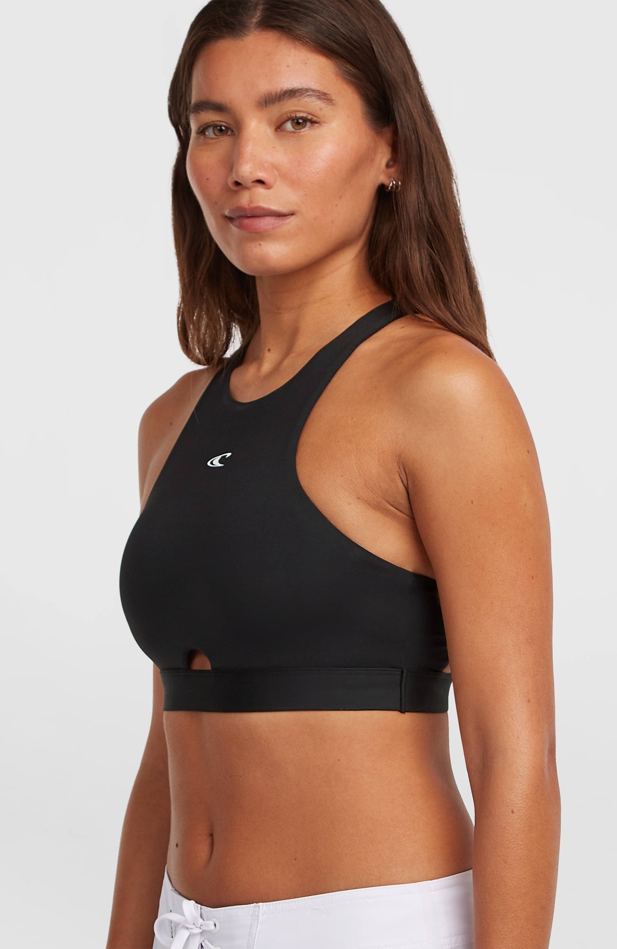 Surftop für Damen, schwarz, Halbprofilansicht am Model, breite Träger und elastisches Unterbrustband