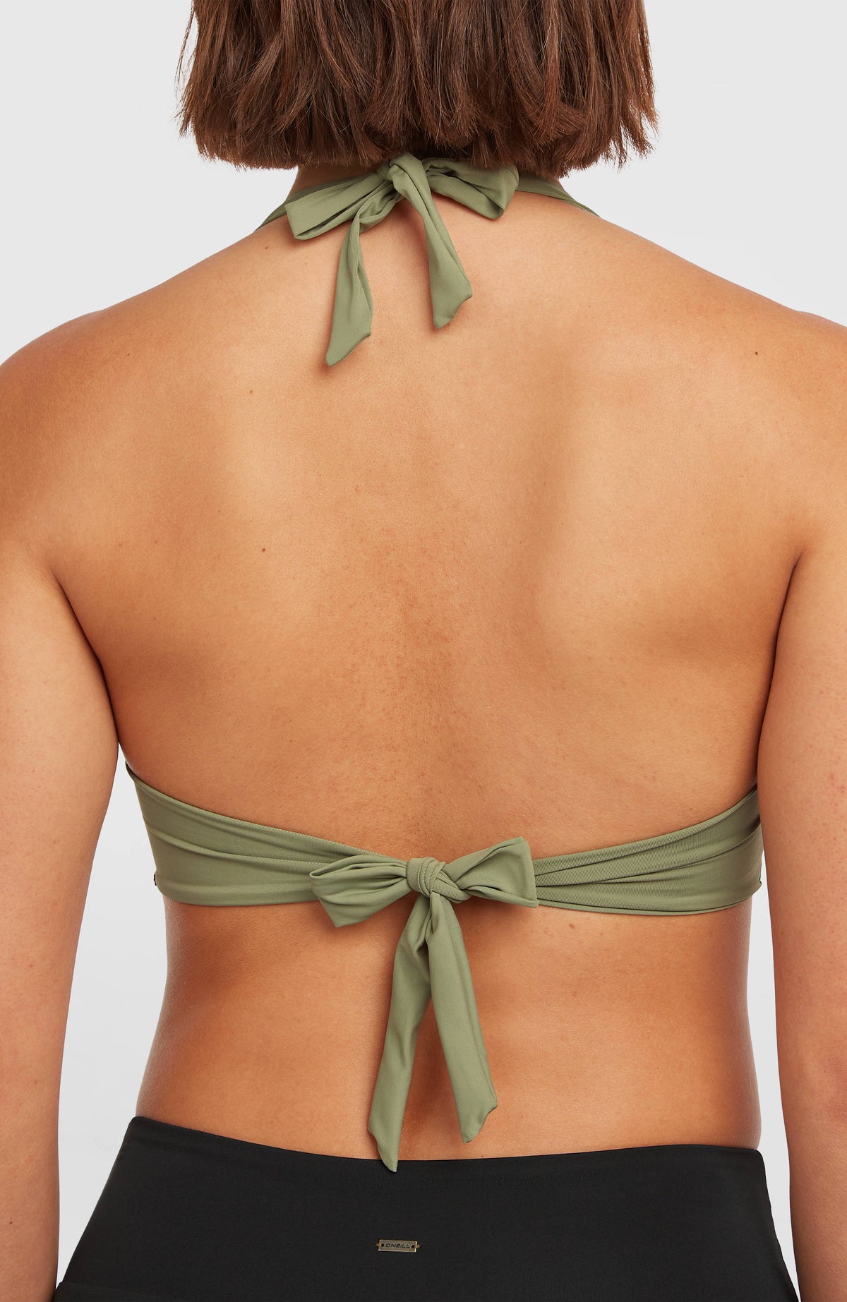 Nahaufnahme des grünen Grenada Bikini-Oberteils am Model von hinten, mit Bindebändern an Verschluss und Trägern