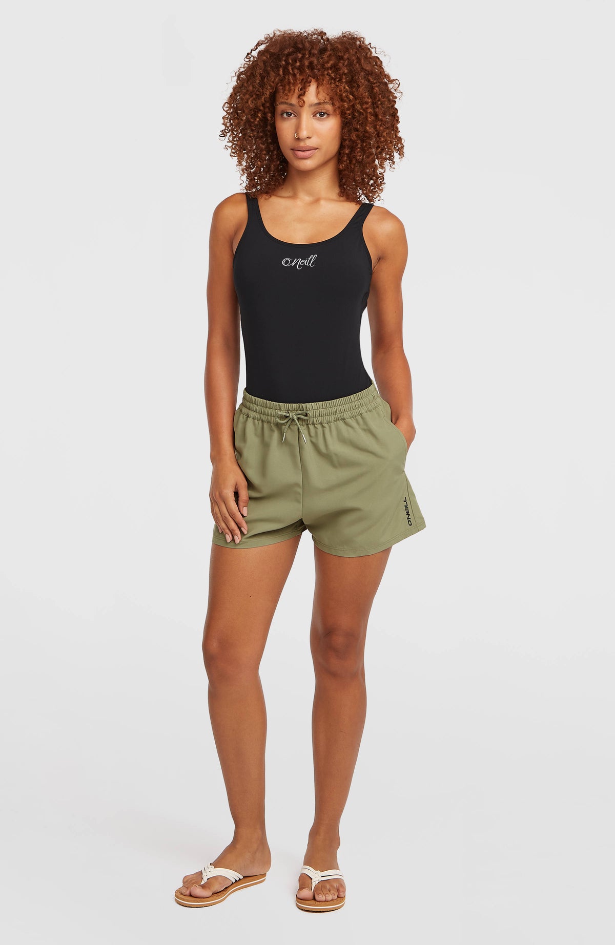 Essentials 12'' Badeshorts für Damen, grün, Vorderansicht am Model mit Logo-Print am Saum