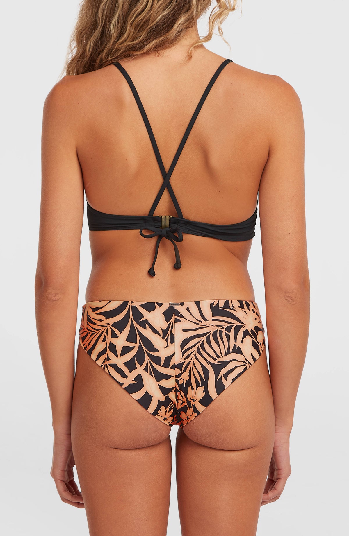O'Neill Maoi Bikinihose für Damen, schwarz mit Blattmuster in Orange, Rückansicht am Model