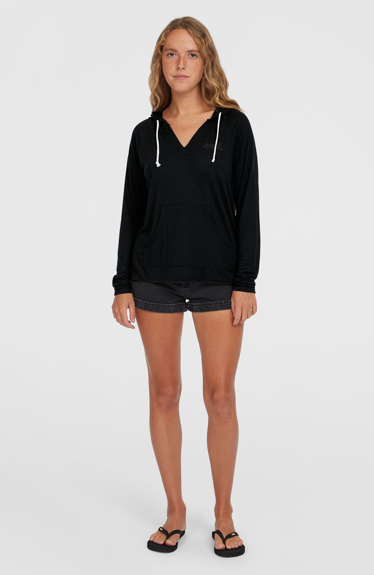 Schwarzer Essentials Langarm-Hoodie für Damen, frontale Ganzkörperansicht getragen am Model mit Kängurutasche