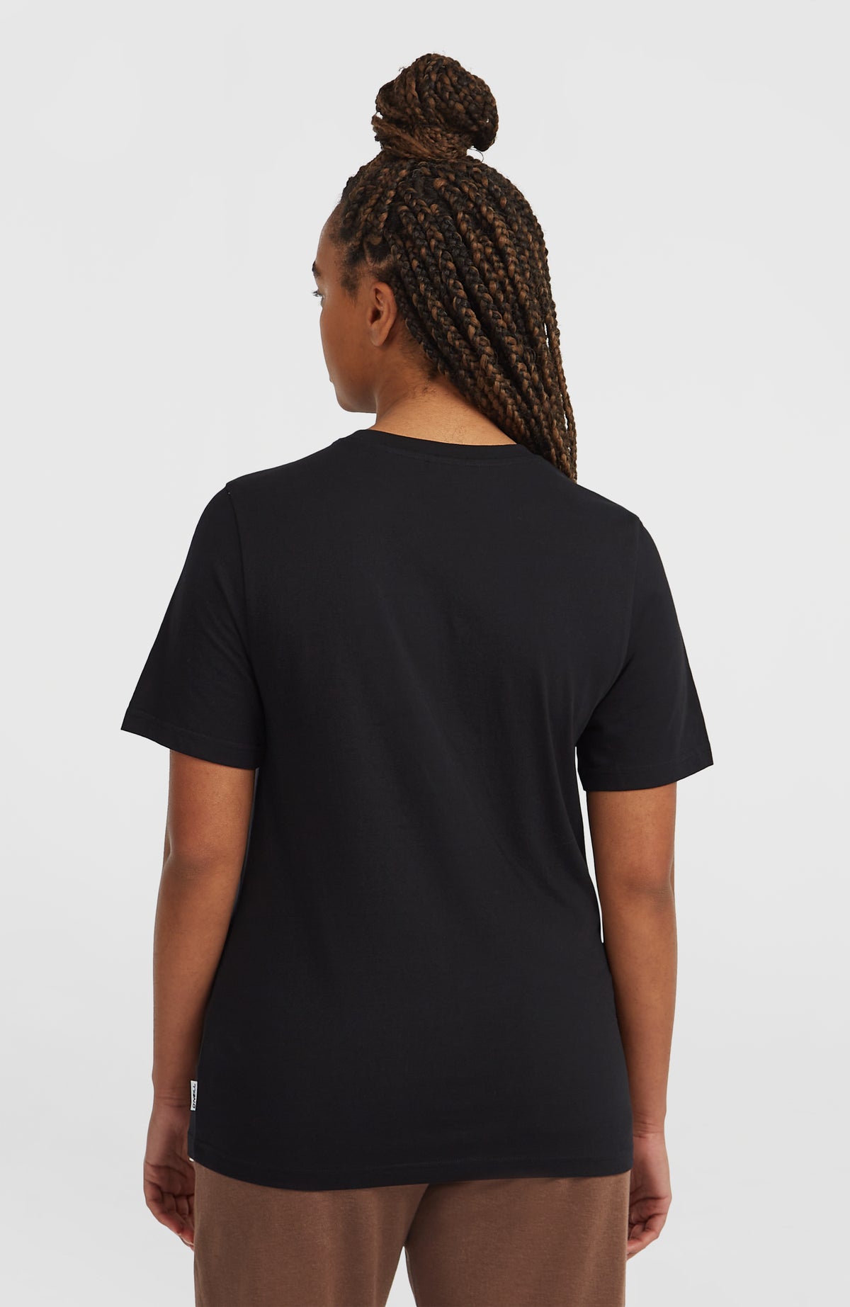 Schwarzes Graphic T-Shirt für Damen, Rückansicht am Model mit dezentem Logo-Label am Bund