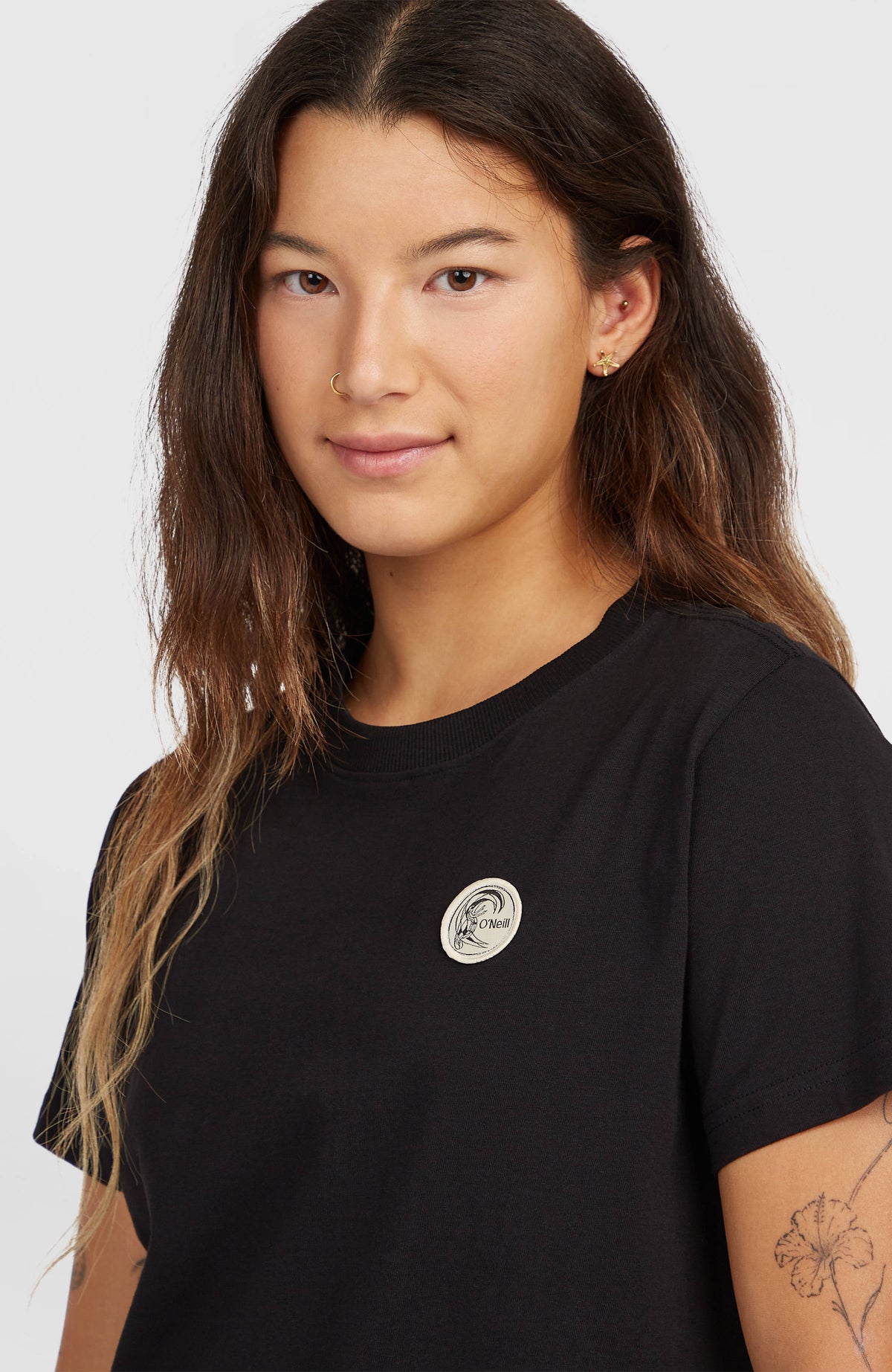 Nahaufnahme von Rundhalsausschnitt und rundem Logo-Badge am schwarzen O'Riginals Badge T-Shirt
