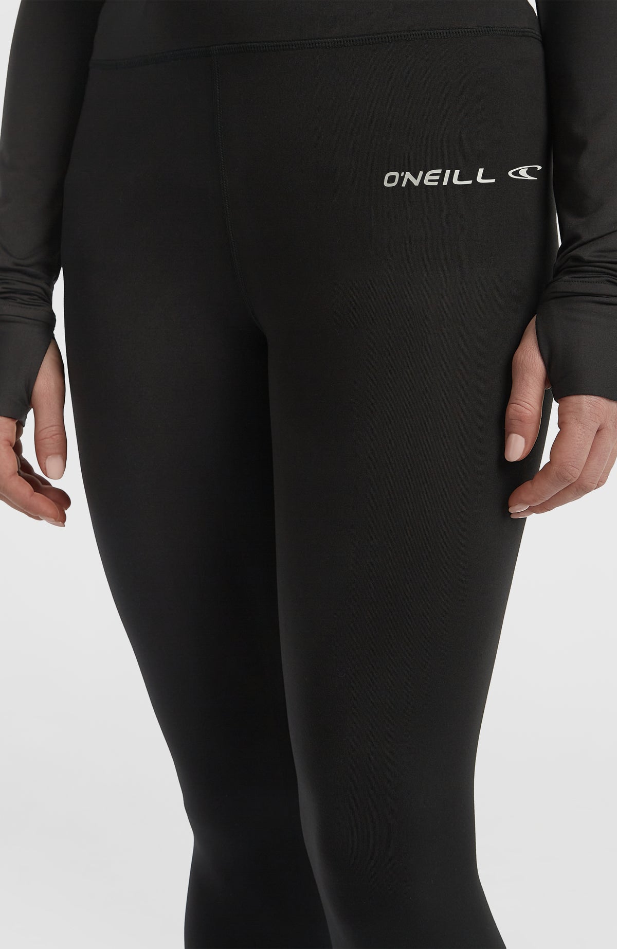 Nahaufnahme der schwarzen Thermounterhose für Damen am Model, Fokus auf Bund und Logo-Print