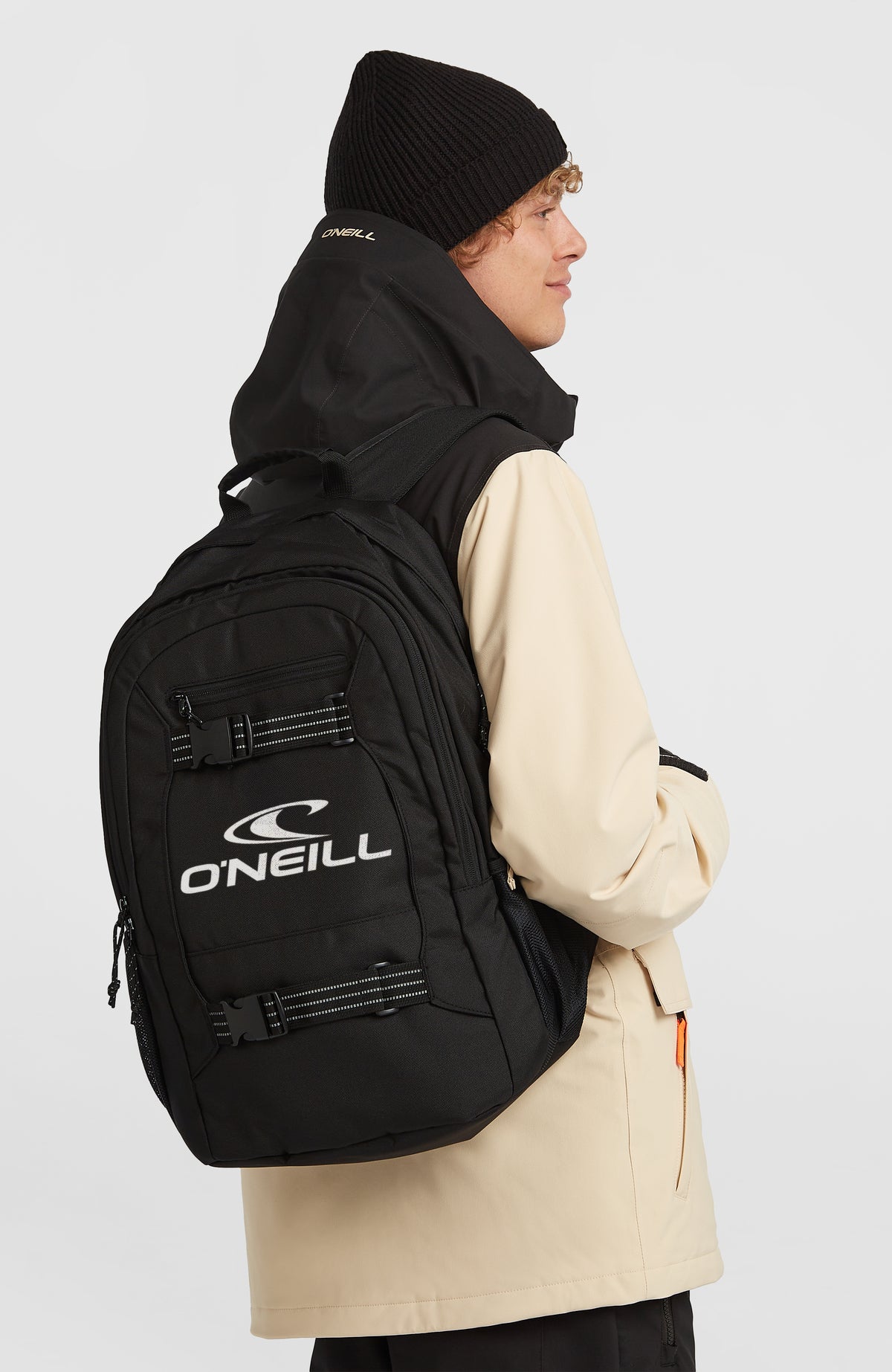 Boarder Rucksack für Herren, schwarz mit Logo-Print in Weiß, getragen am Model in Seitenansicht