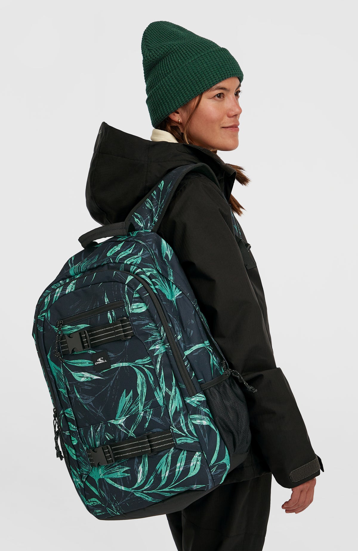 Boarder Rucksack für Herren, blau mit Palmenmuster in Grün, getragen am Model von der Seite