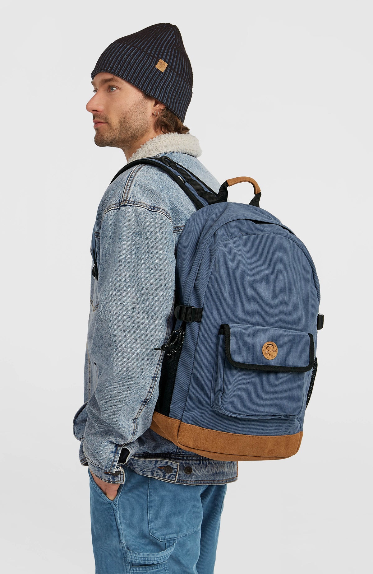 O'Riginals Rucksack, blau, getragen am Model von der Seite mit seitlicher Netztasche und verstellbarem Riemen