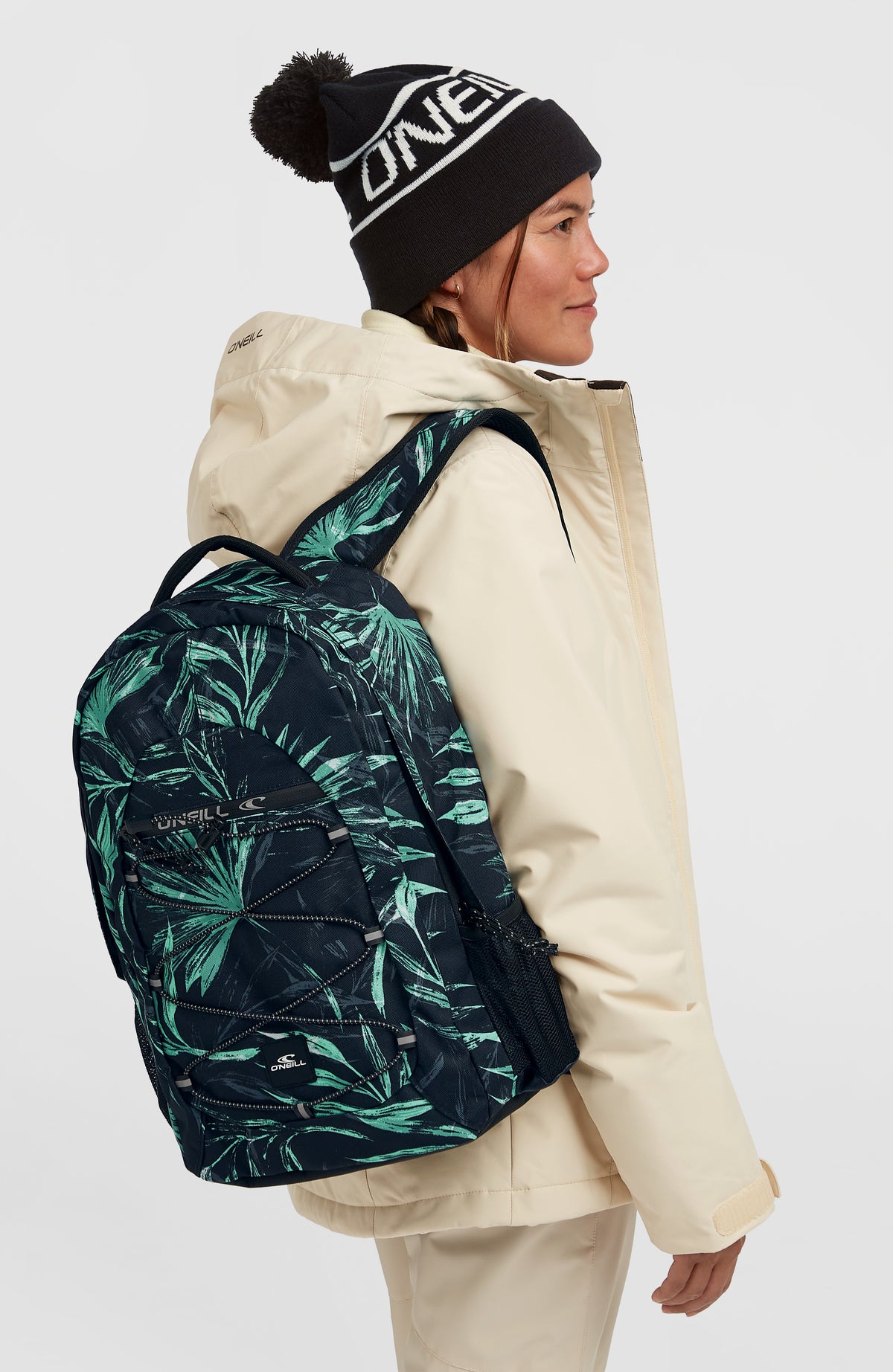Kleiner Boarder Rucksack für Herren, blau mit Palmenmuster in Grün, getragen am Model, Seitenansicht