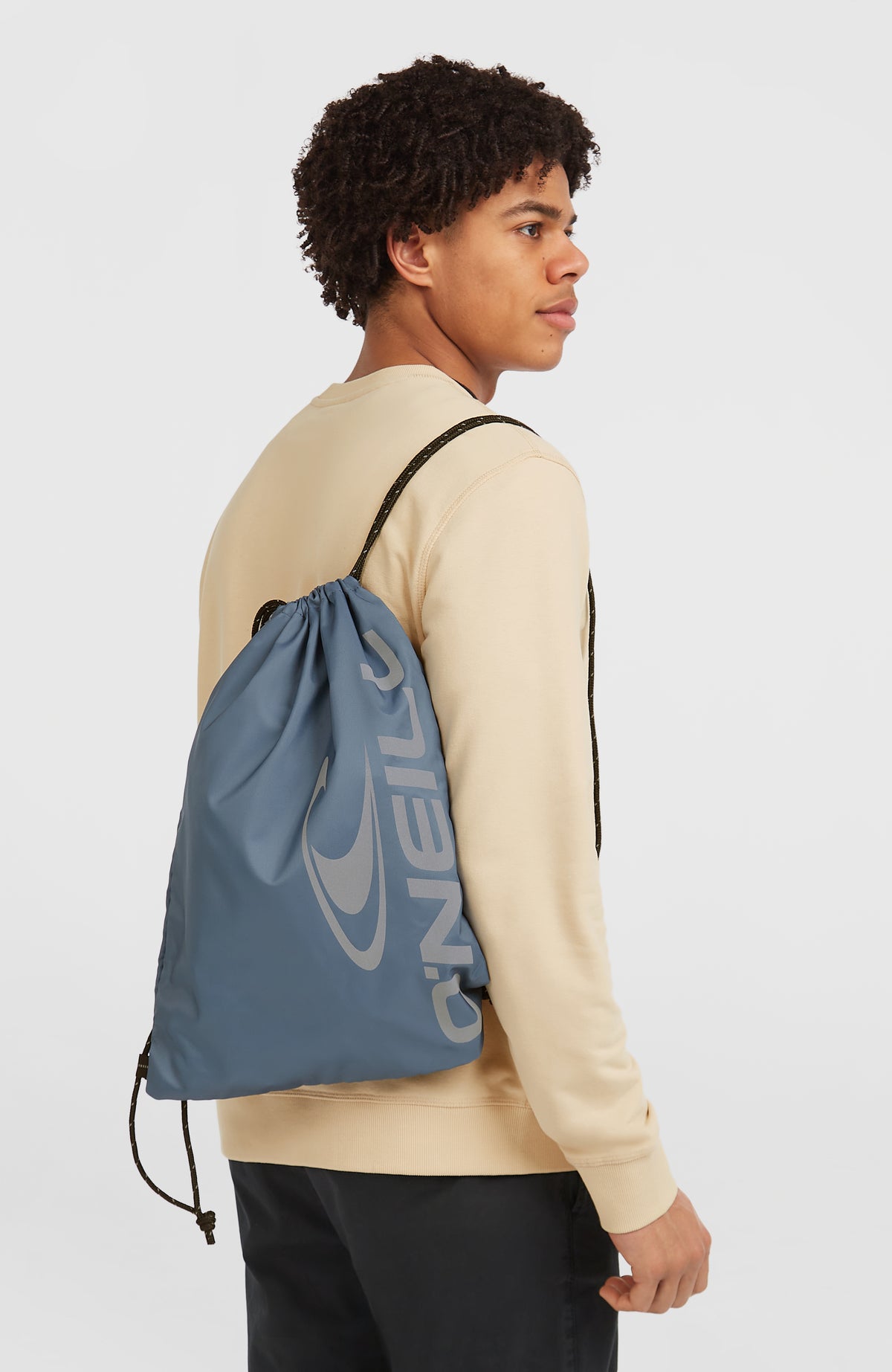 Turnbeutel für Herren, blau mit Logo-Print in Grau, getragen am Model in der Halbprofilansicht