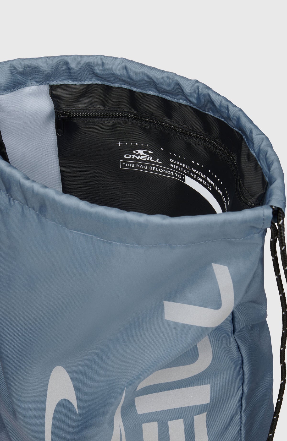 Nahaufnahme des blauen Turnbeutels mit Logo-Print in Grau, Blick in die Öffnung mit Reißverschluss-Innenfach