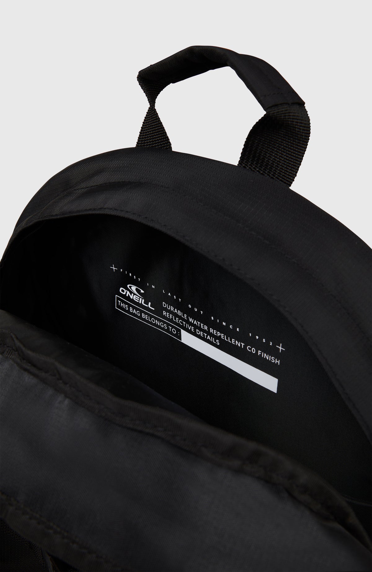 Nahaufnahme des geöffneten Innenfachs mit Namensschild am schwarzen Surfer Rucksack