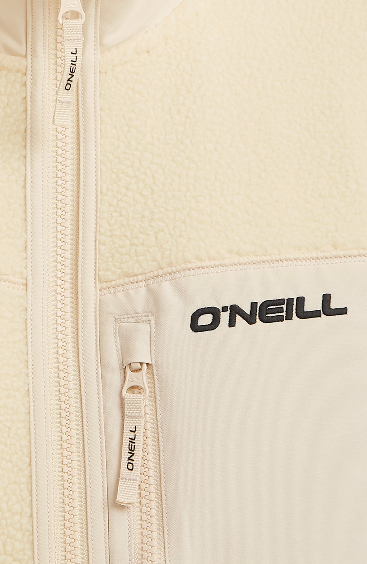 Nahaufnahme der Brusttasche mit Logo-Schriftzug der beigen Flauschige Must-Have Fleecejacke