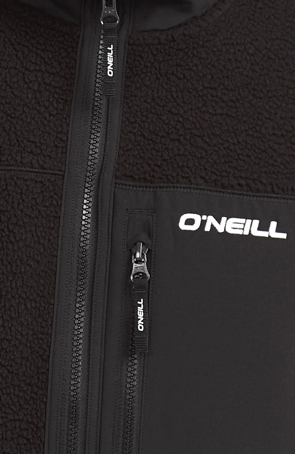 Nahaufnahme von Reißverschluss und Brusttasche der schwarzen Flauschige Must-Have Fleecejacke
