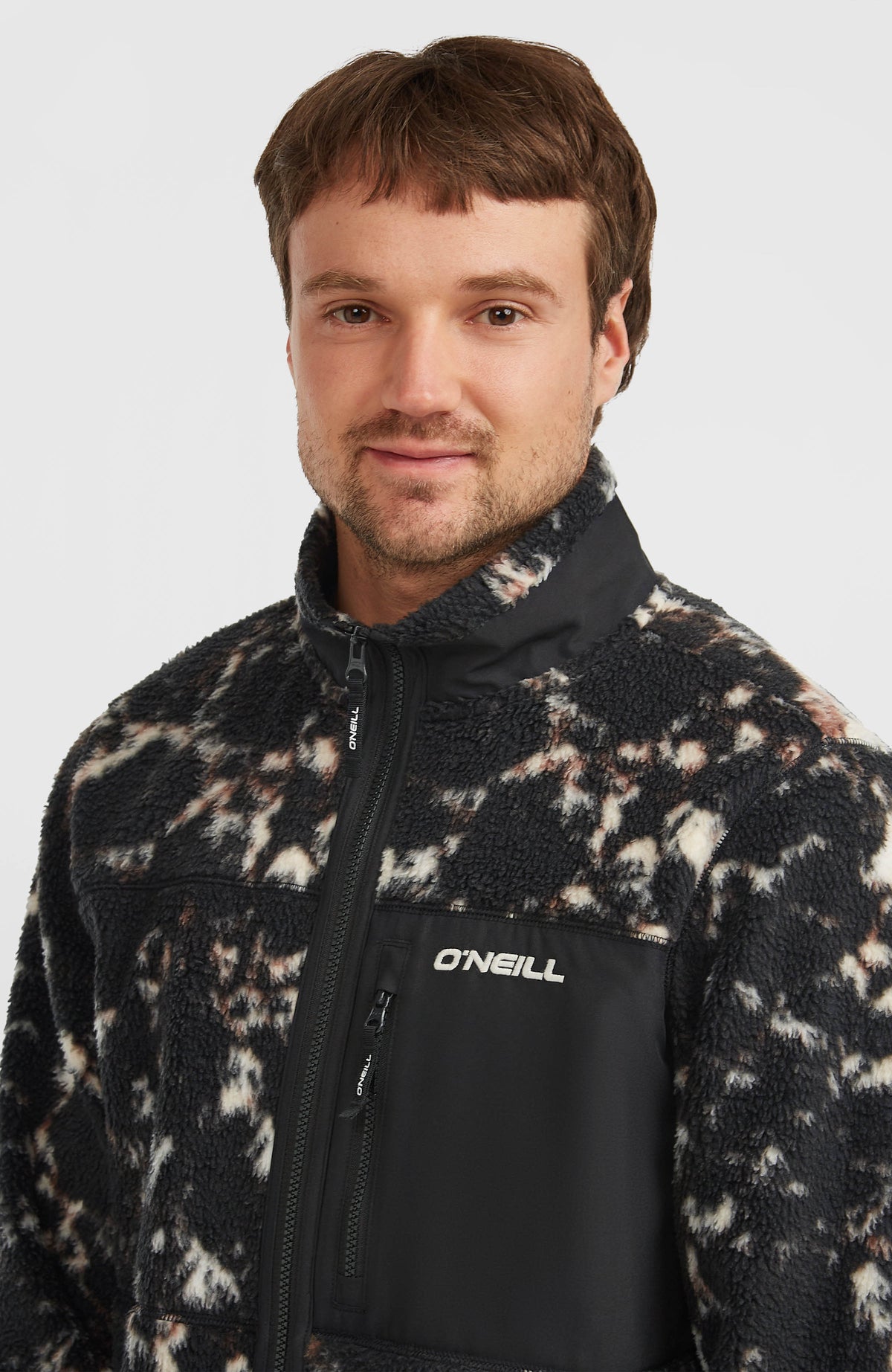 Flauschige Must-Have Fleecejacke, schwarz mit Muster in Beige, Nahaufnahme mit Stehkragen und Brusttasche
