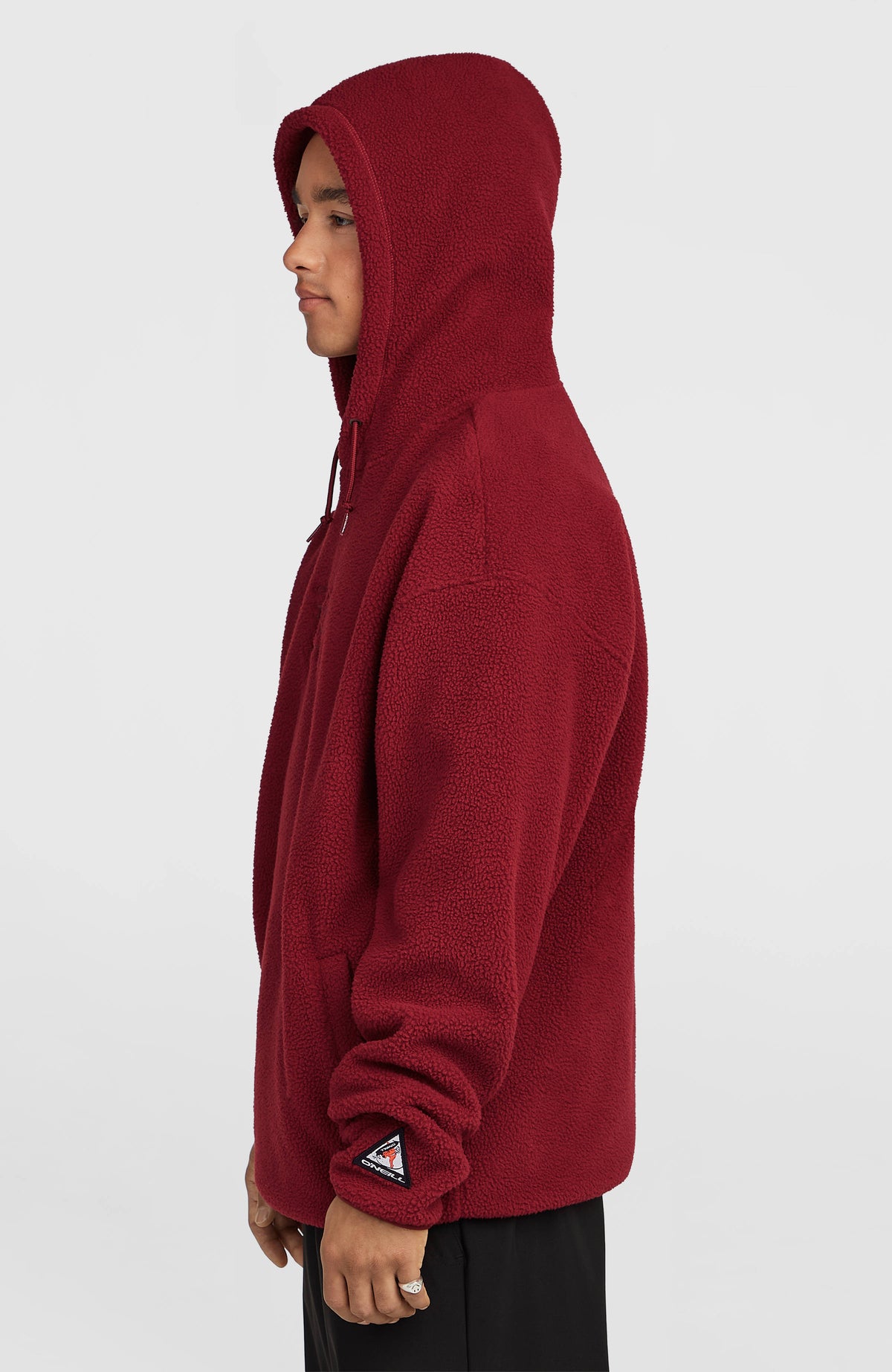 Flauschiger FWC'Play Fleece-Hoodie für Herren, rot, Seitenansicht am Model mit aufgesetzter Kapuze und Ärmel-Badge