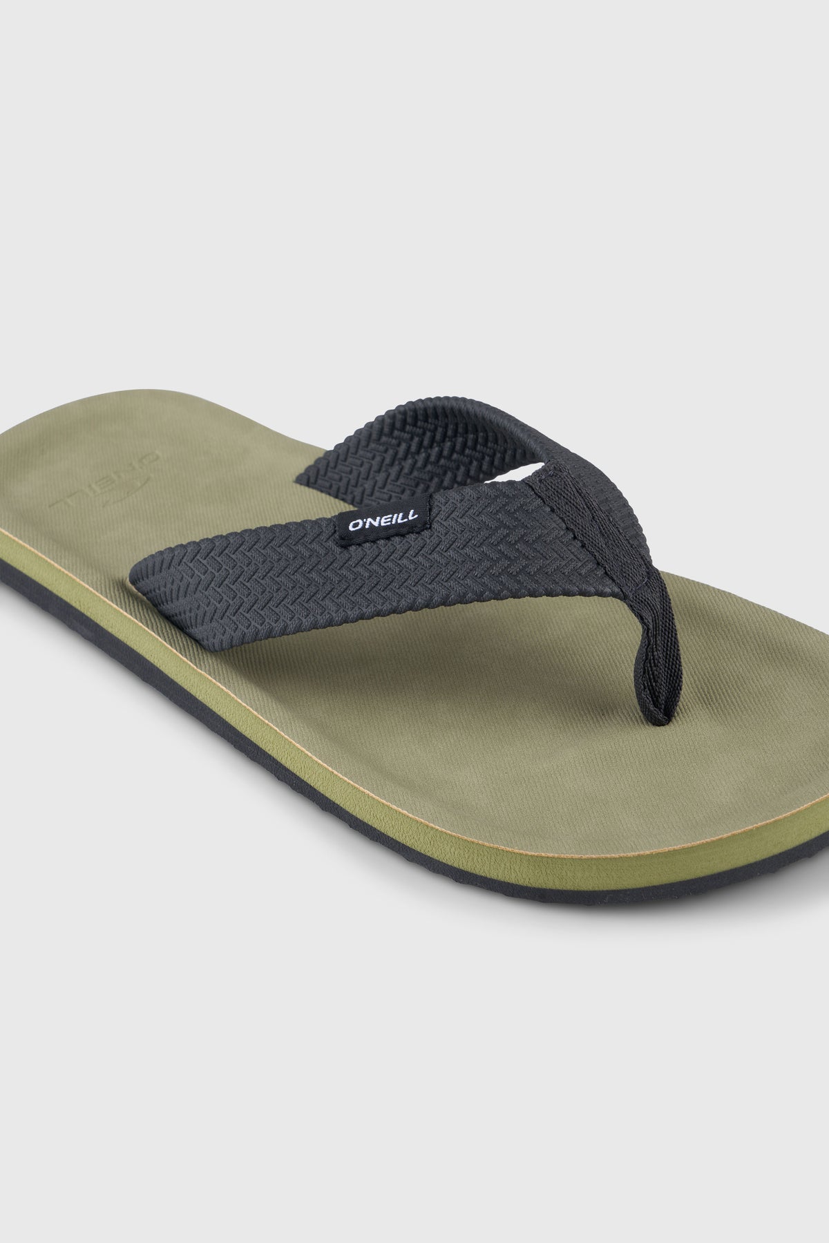 Nahaufnahme der grünen Chad Sandalen mit gewebtem Zehenriemen und Logo-Label