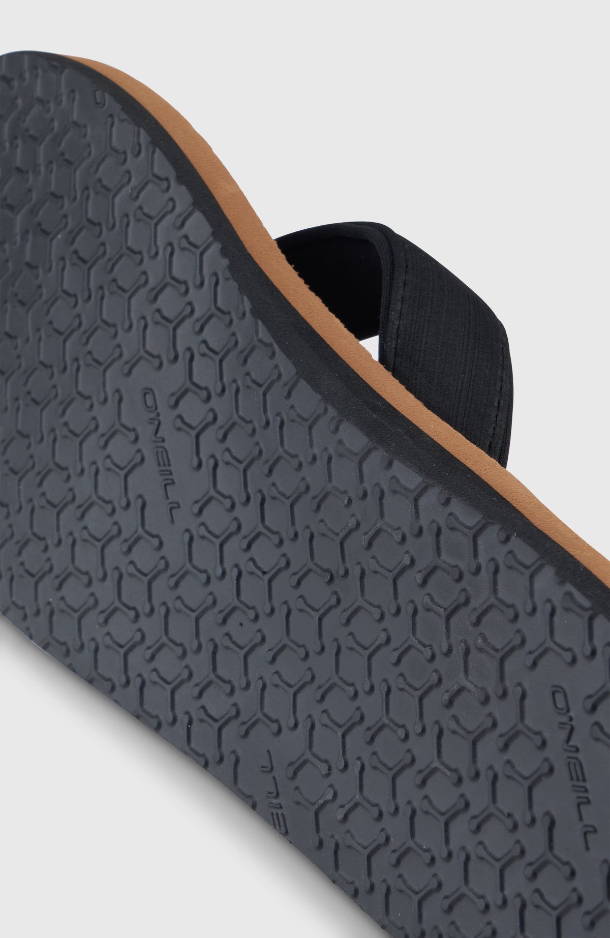 Nahaufnahme der profilierten schwarzen Sohle der braunen Koosh Sandalen