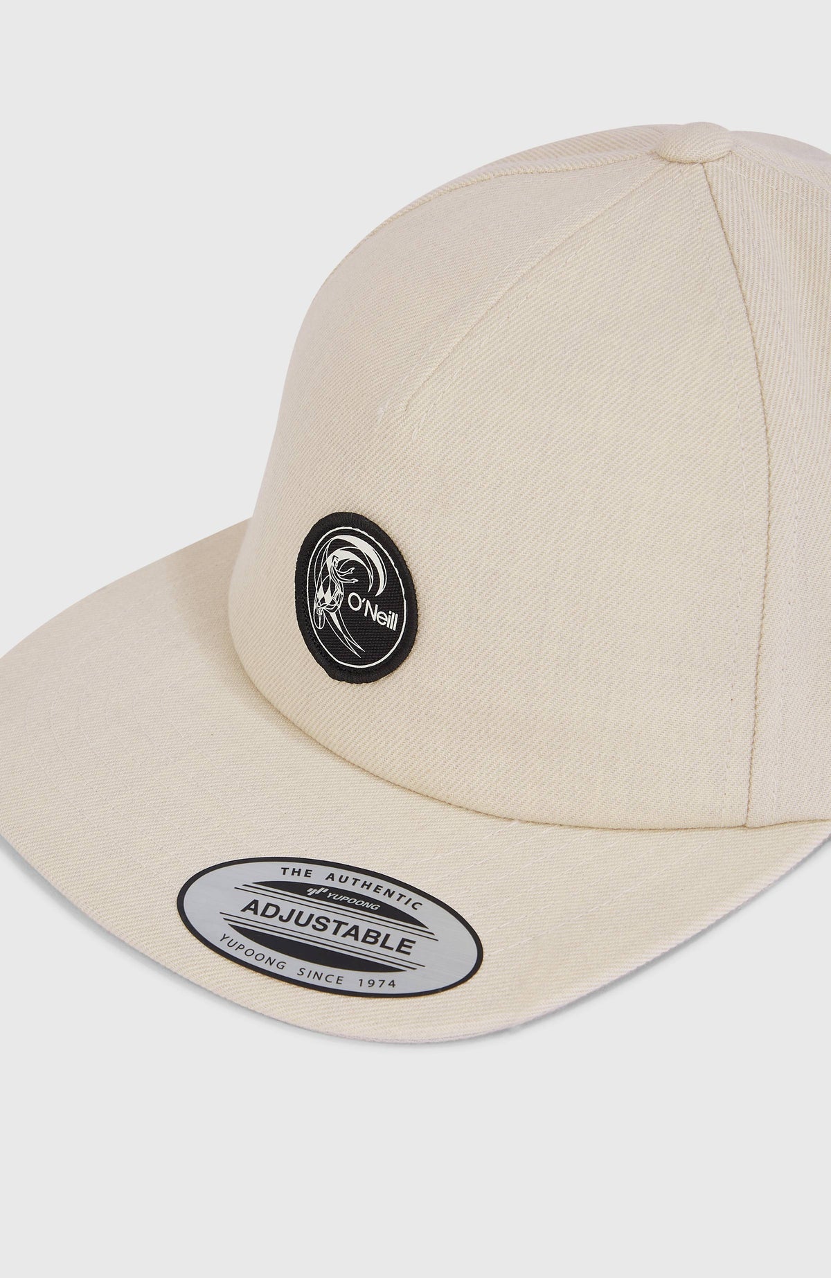 Nahaufnahme der beigen O'Riginals Cap mit flachem Schirm und rundem Logo-Patch auf der Vorderseite