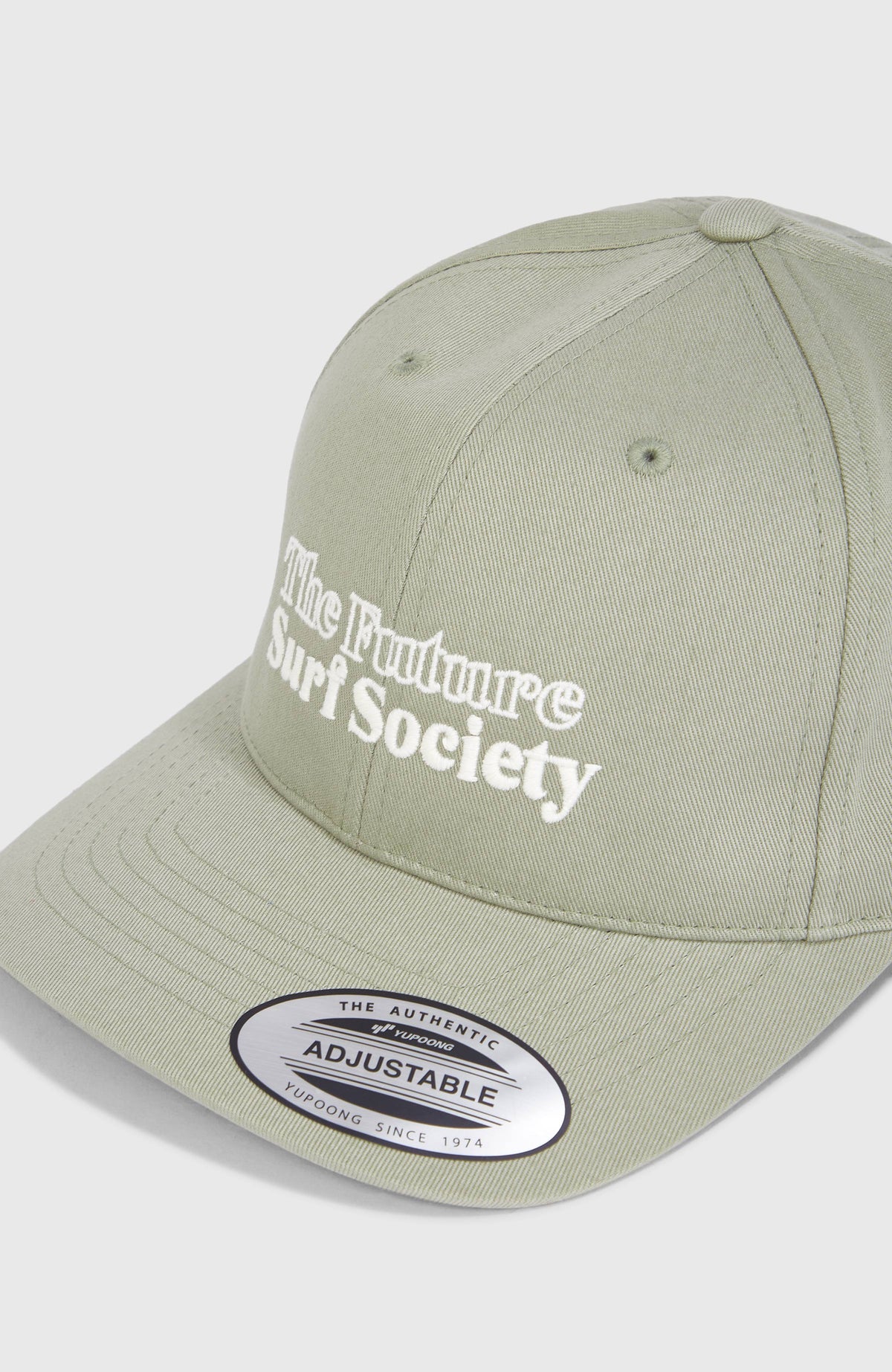 Nahaufnahme der Vorderseite der grünen Future Surf Society Cap für Herren mit Schriftzug in Weiß