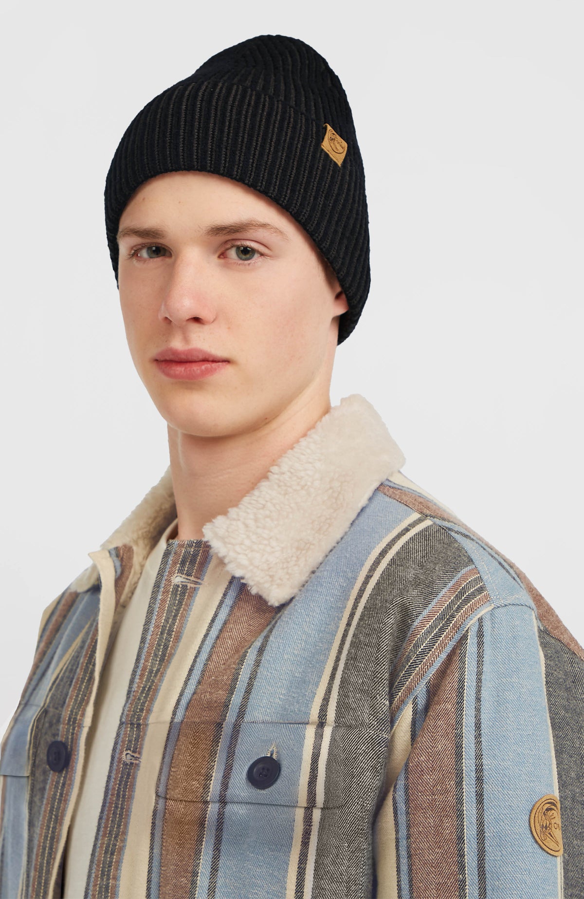 O'Riginals Beanie, schwarz, getragen am Model im Studio, leicht schräge Vorderansicht mit geripptem Umschlag
