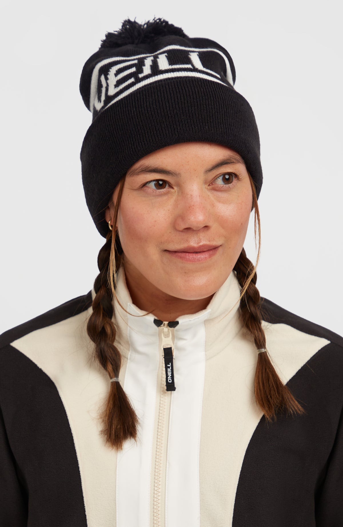 Powder Beanie für Herren, schwarz mit Logo-Schriftzug in Weiß, getragen am Model in Halbprofil-Ansicht