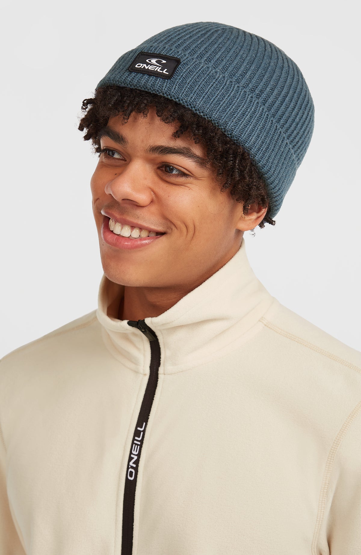 Bouncer Beanie für Herren, blau, getragen am Model von schräg vorne mit Logo-Patch am Umschlag