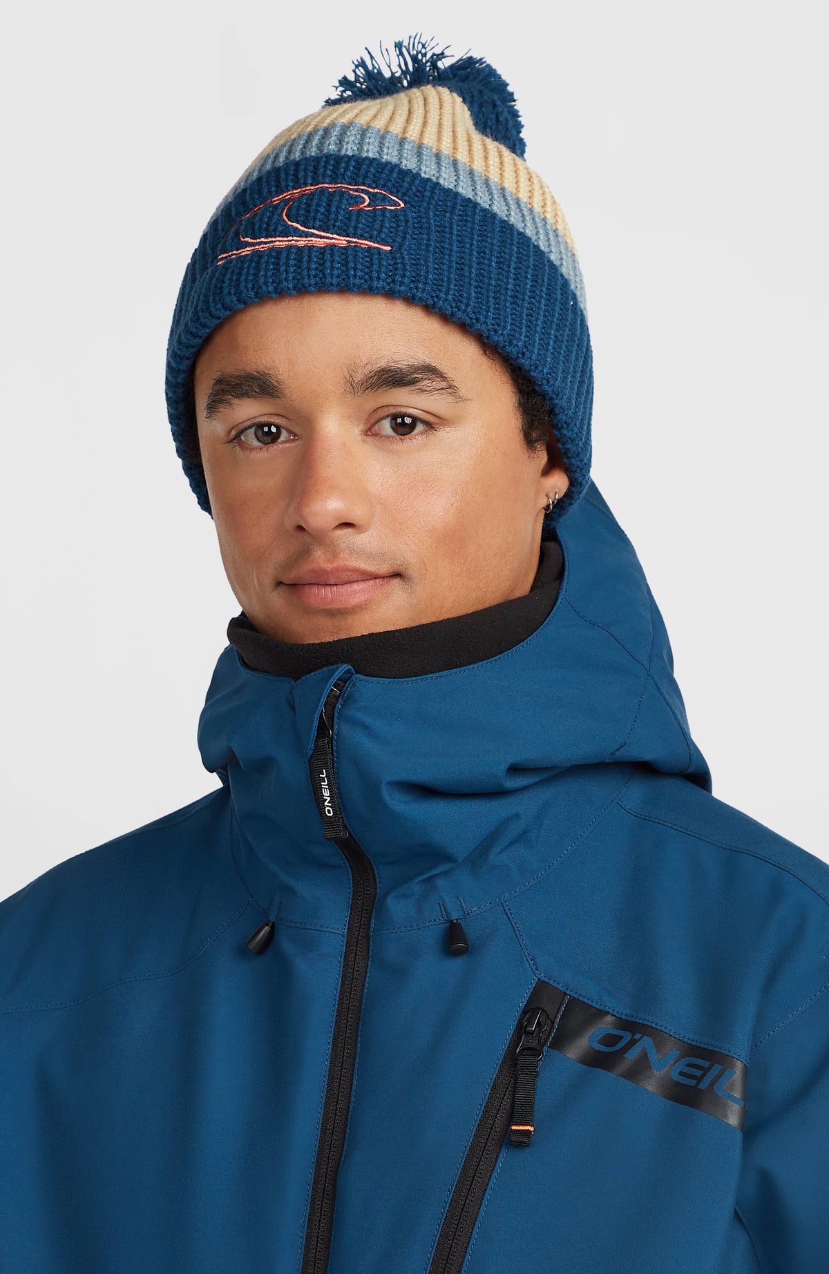 Powder Beanie für Herren, blau mit Streifenmuster in Beige und Grau, getragen am Model, Frontalansicht mit Umschlag