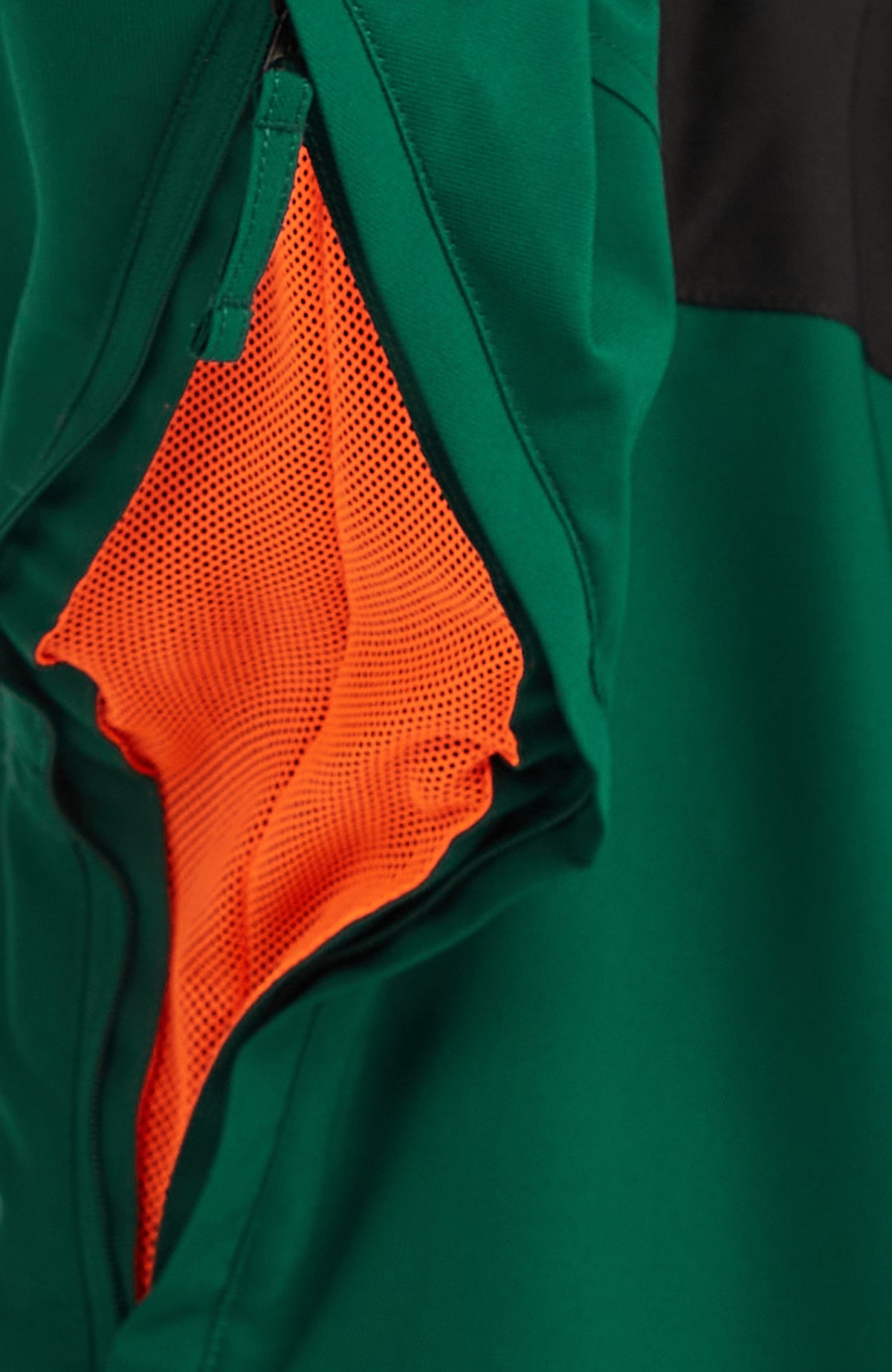 Detailaufnahme des Belüftungsreißverschlusses mit orangefarbenem Mesh der grünen FWC'Peak Skijacke