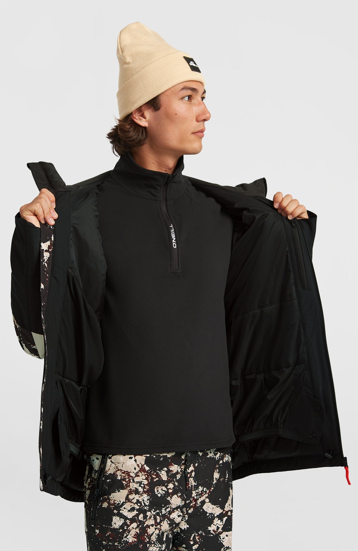 FWC'Cruz Triple Skijacke, schwarz mit Allover-Muster in Beige, geöffnet am Model mit Blick auf das Innenfutter