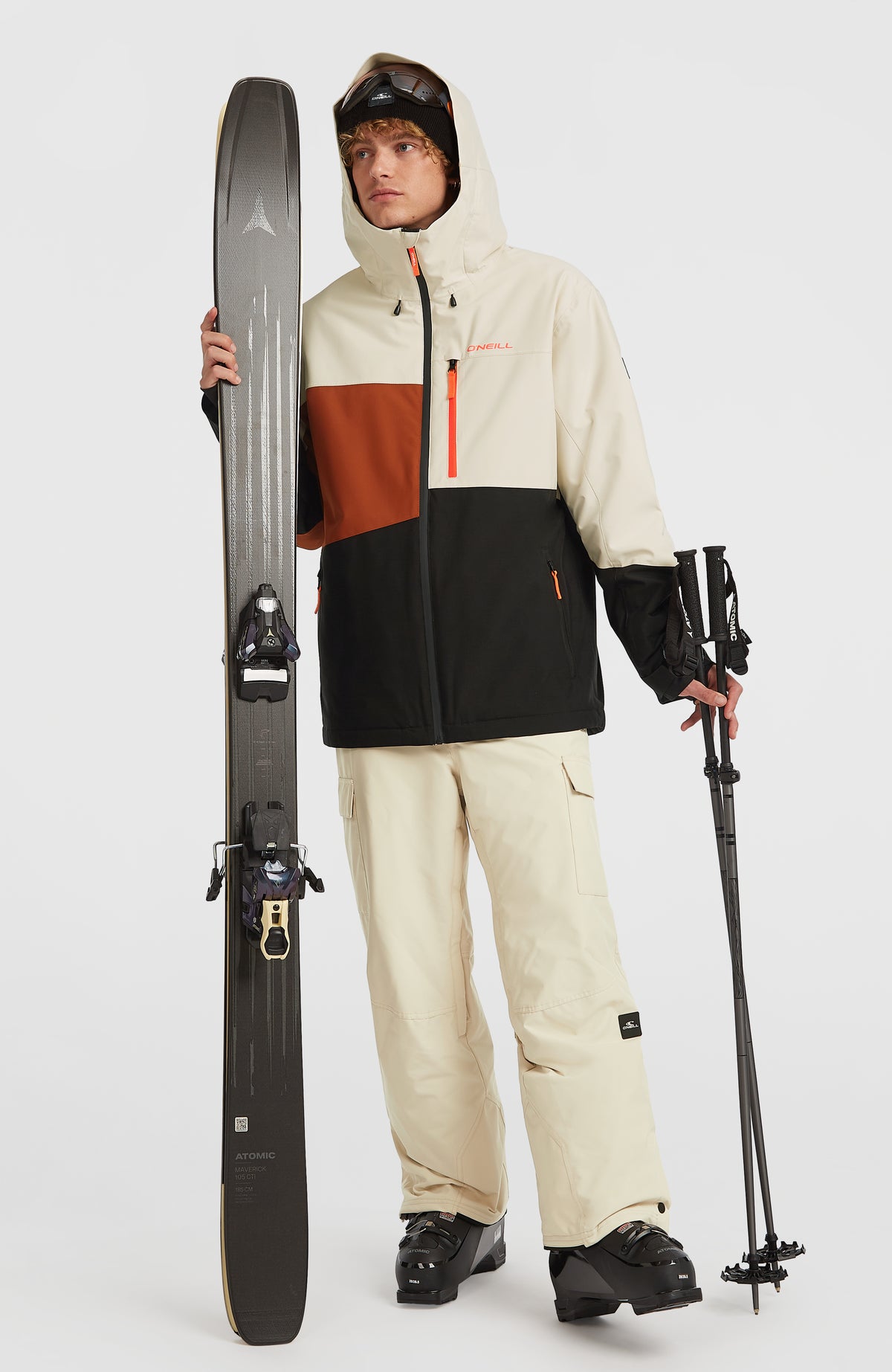 FWC'Cruz Triple Skijacke für Herren, beige, getragen am Model, Gesamtansicht von vorne mit Skiern und Stöcken