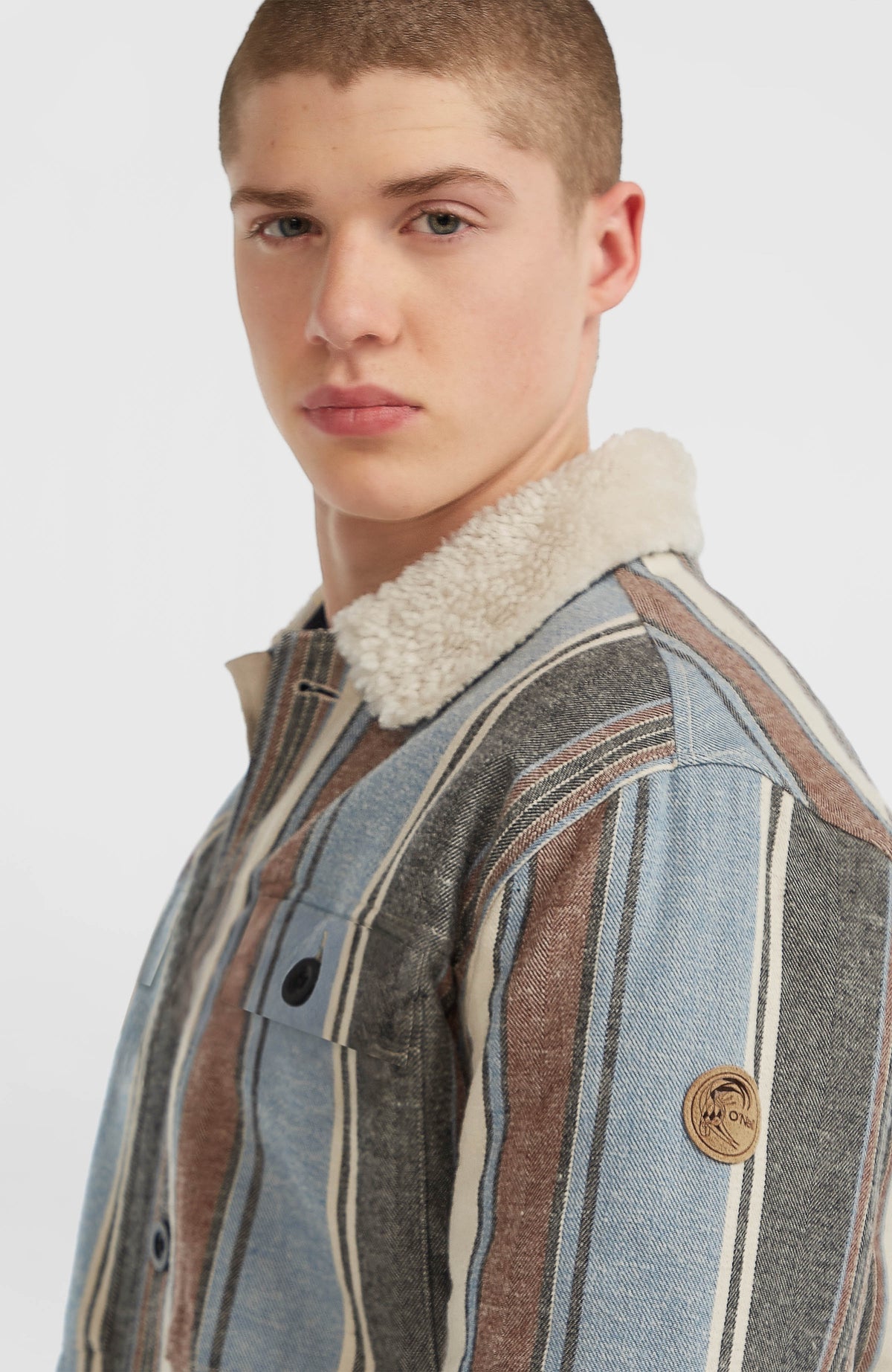 O'Riginals Jacke mit Fleecefutter, blau mit Streifenmuster in Braun, Nahaufnahme des Logo-Patches am Ärmel