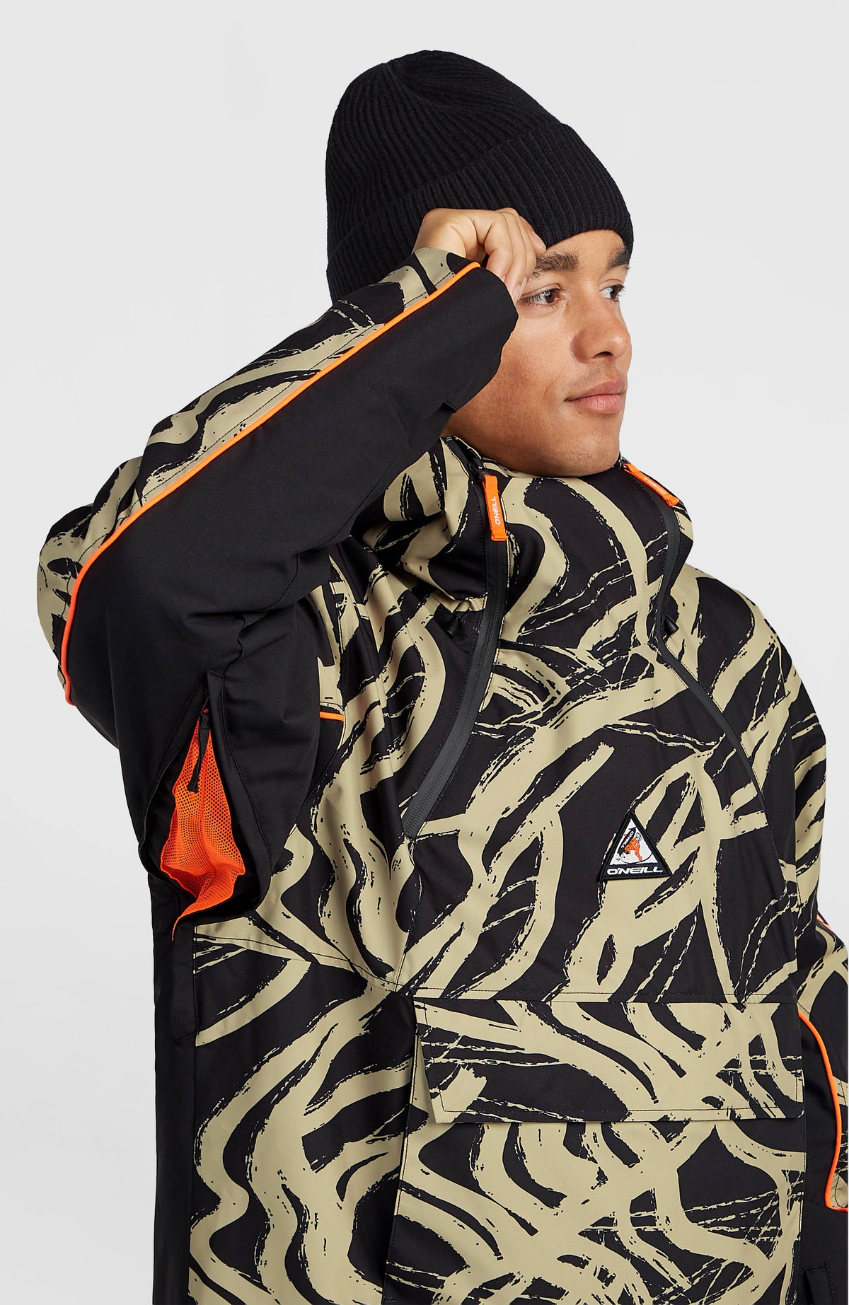 FWC'Play Asymmetric Ski- und Snowboardjacke, beige mit Grafikmuster in Schwarz, Belüftungsreißverschluss am Ärmel